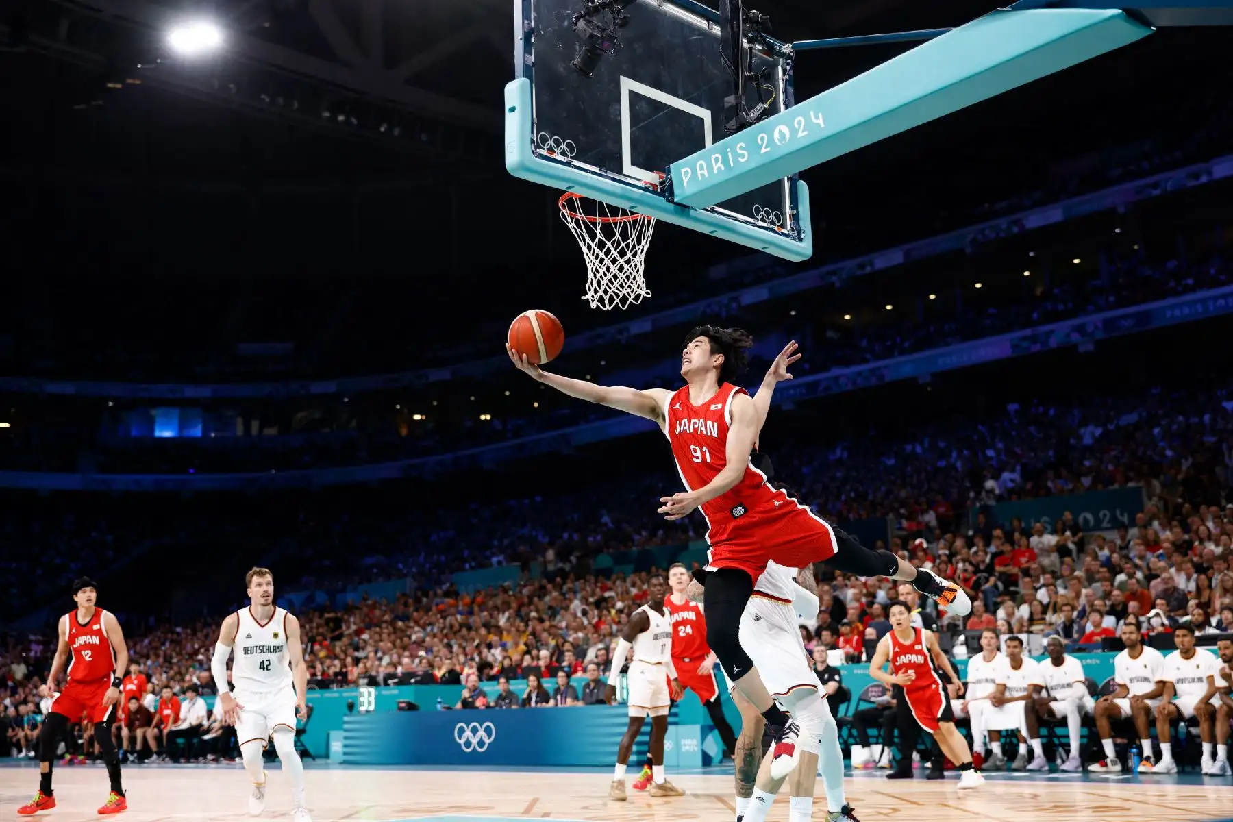 El japonés  Hirotaka Yoshii va a la canasta y anota en el partido de baloncesto del grupo B de la ronda preliminar masculina entre Alemania y Japón durante los Juegos Olímpicos de París 2024. AFP