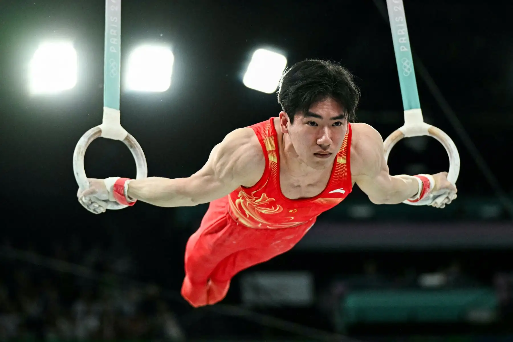 El chino Zhang Boheng compite en la prueba de anillos de la clasificación masculina de gimnasia artística durante los Juegos Olímpicos de París 2024. Foto: AFP