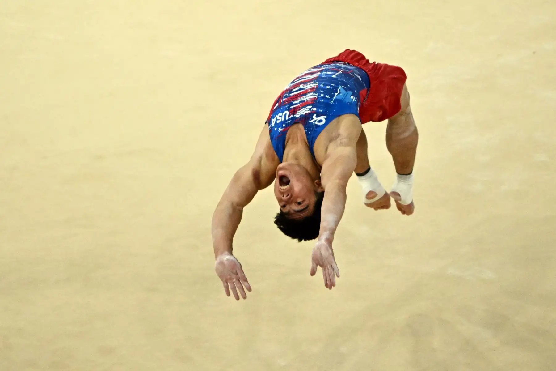 El estadounidense Asher Hong compite en la prueba de suelo de la clasificación masculina de gimnasia artística durante los Juegos Olímpicos de París 2024. AFP