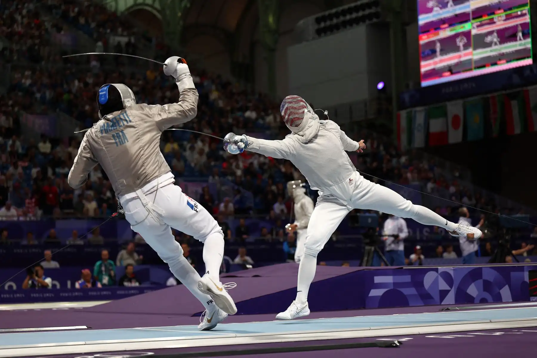 El francés Maxime Pianfetti y el estadounidense Mitchell Saron compiten en la ronda individual de sable masculino de 32 durante los Juegos Olímpicos de París 2024. AFP