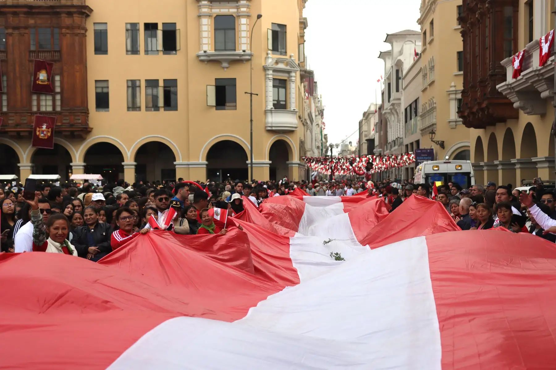 Lima se prepara para recibir el aniversario patrio; pasacalles, comparsas, venta de postres y potajes tradicionales. 
Pasean la bandera nacional que tiene más de 80 metros, en la Plaza  Mayor de Lima.
Foto: ANDINA / Lino Chipana.