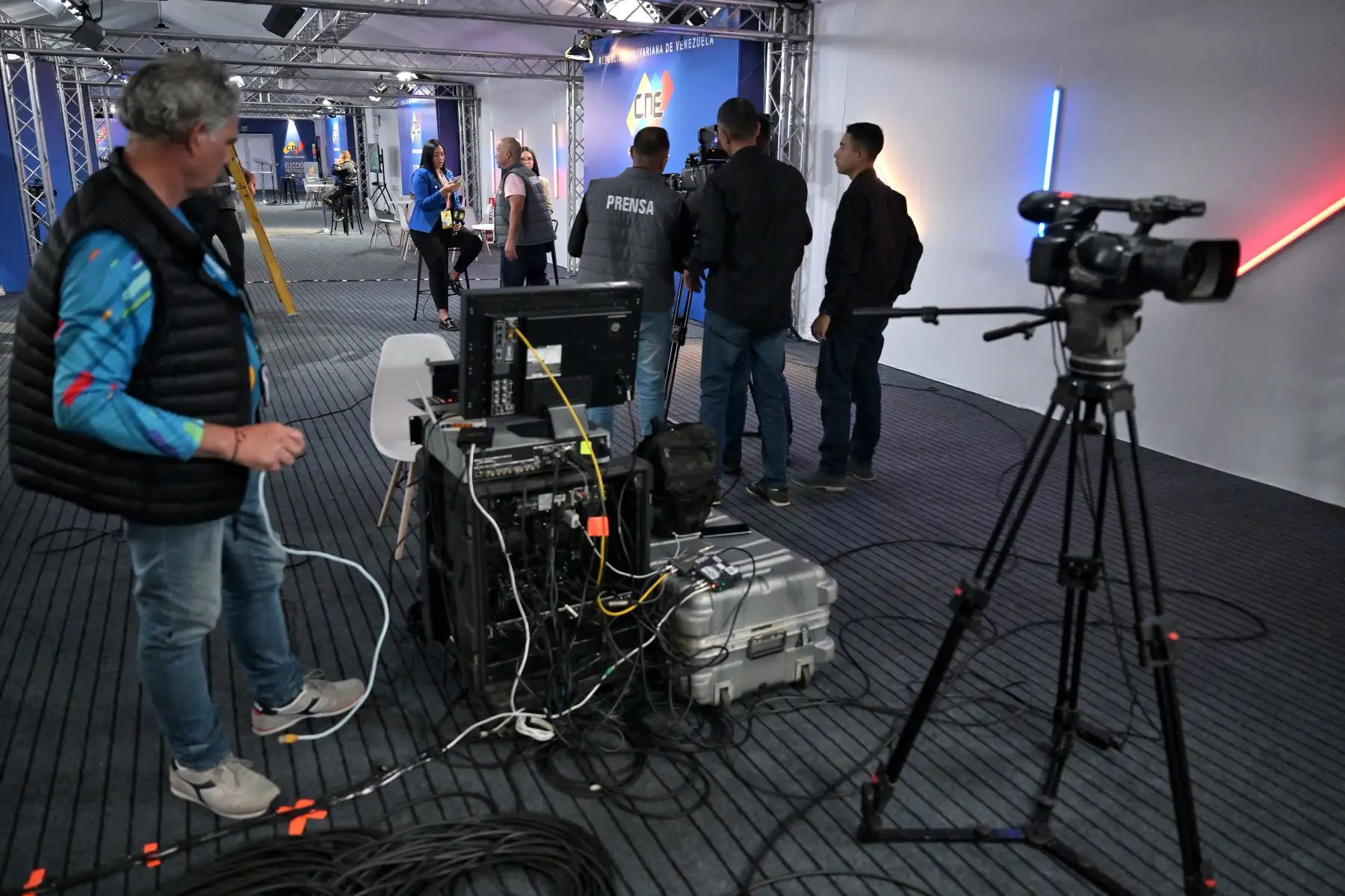 Un técnico de un canal de televisión aparece dentro del centro de medios del Consejo Nacional Electoral (CNE) en Caracas. Venezuela celebrará elecciones presidenciales el 28 de julio de 2024.
Foto: AFP