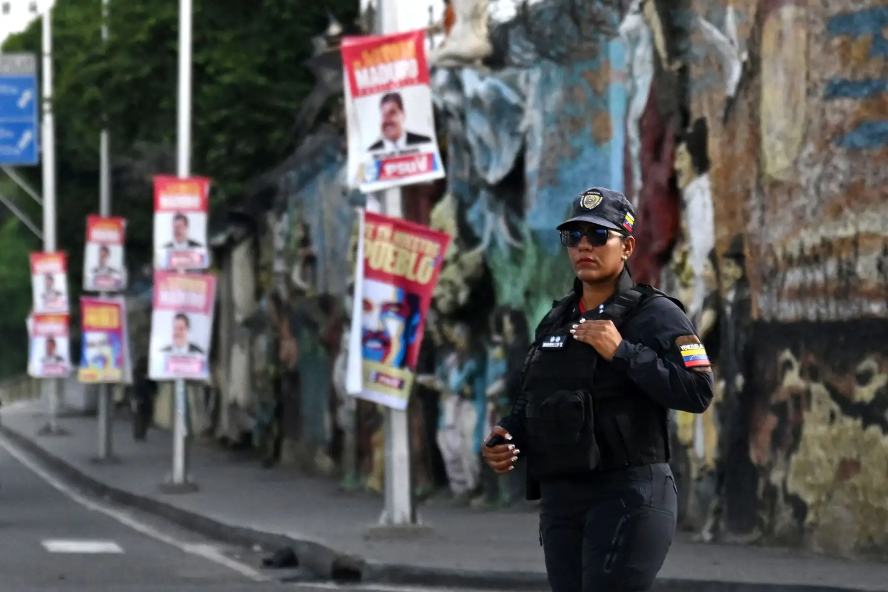 Una mujer policía venezolana vigila una calle junto a pancartas con la imagen del presidente y candidato presidencial venezolano, Nicolás Maduro, en Caracas.
Foto: AFP