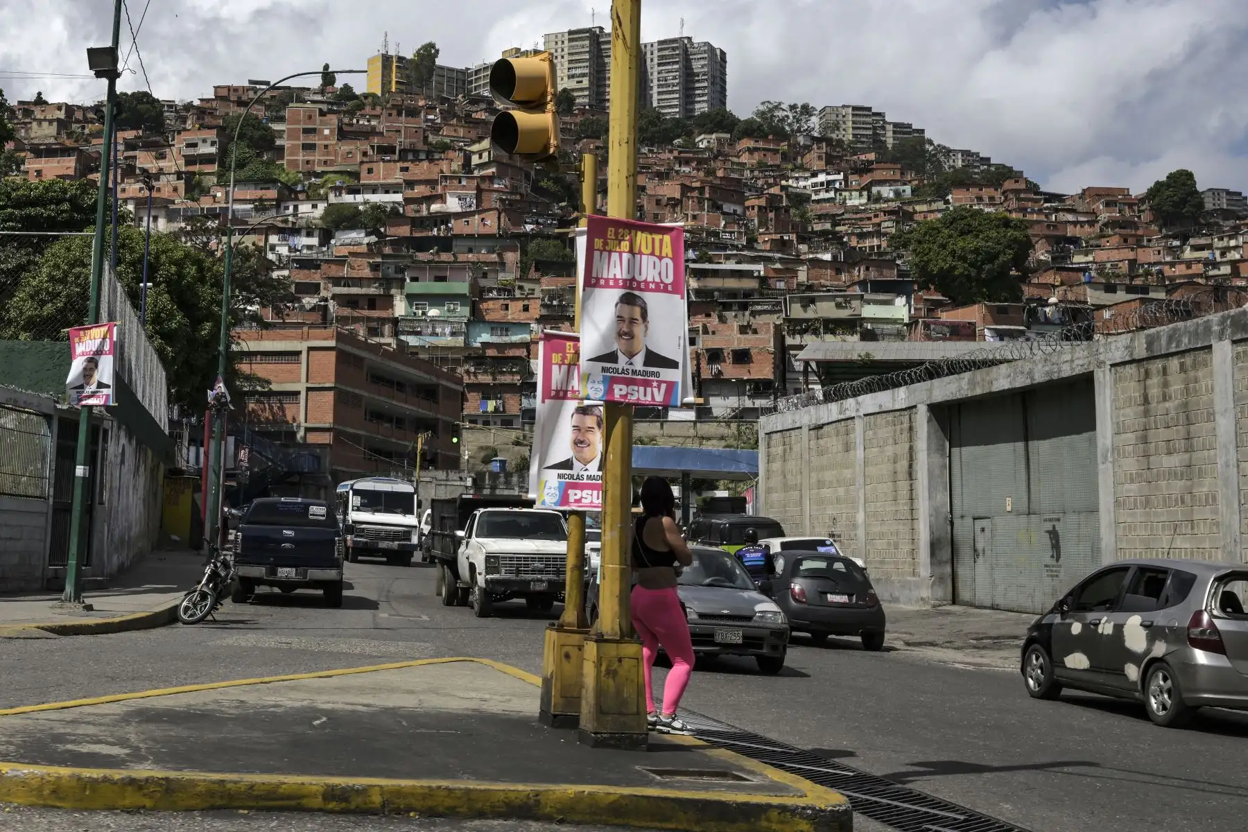 Una mujer espera cruzar la calle debajo de una pancarta del presidente y candidato presidencial venezolano, Nicolás Maduro, en el barrio 23 de Enero en Caracas. Venezuela celebrará elecciones presidenciales el 28 de julio de 2024.
Foto: AFP