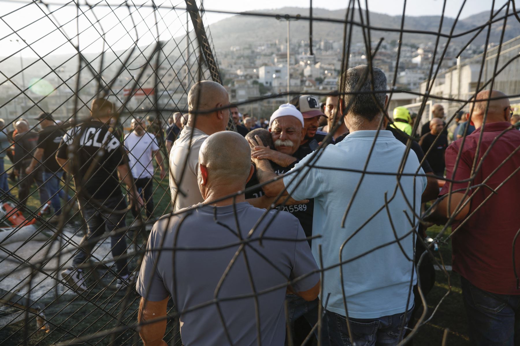 Los residentes locales se consuelan mutuamente mientras se reúnen en un lugar donde supuestamente cayó un ataque desde el Líbano en la aldea de Majdal Shams en el área del Golán anexada por Israel.
Foto: AFP