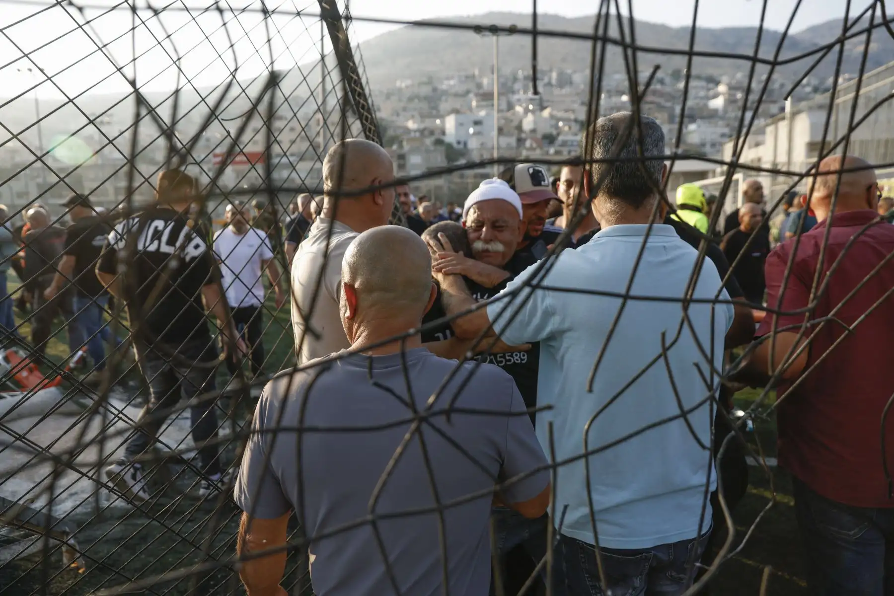 Los residentes locales se consuelan mutuamente mientras se reúnen en un lugar donde supuestamente cayó un ataque desde el Líbano en la aldea de Majdal Shams en el área del Golán anexada por Israel.
Foto: AFP