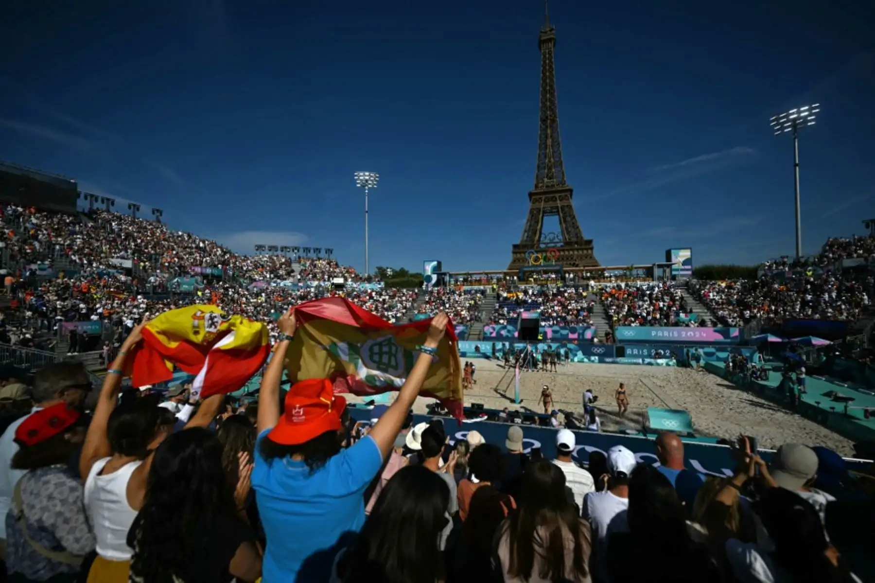 Aficionados españoles animan a su país durante el partido de voleibol de playa entre Italia y España de los Juegos Olímpicos de París 2024 en el Estadio de la Torre Eiffel, el 28 de julio. Foto: AFP
