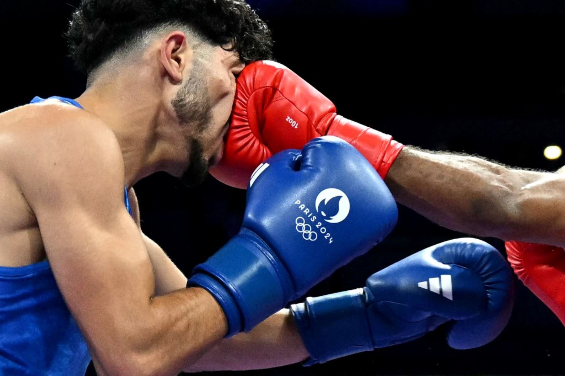 El palestino Wasim Abusal (de azul) recibe un puñetazo del sueco Nebil Ibrahim en el partido de boxeo preliminar de dieciseisavos de final de la categoría de 57 kg durante los Juegos Olímpicos de París 2024 en el Arena del Norte de París, en Villepinte, el 28 de julio de 2024. Foto: MOHD RASFAN / AFP