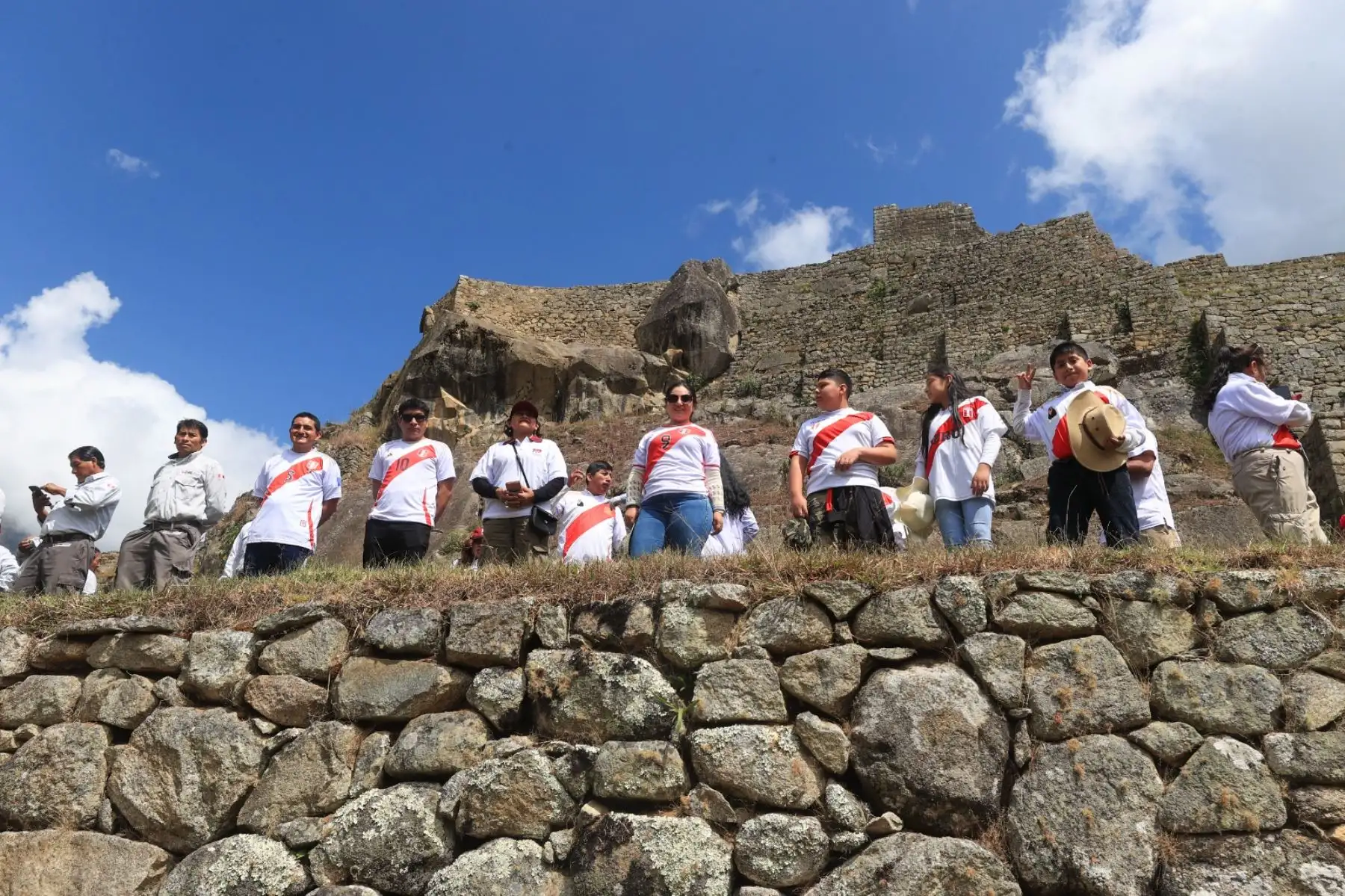 Con motivo del 203º Aniversario de la Proclamación de la Independencia Nacional, la región de Cusco celebra una ceremonia especial por Fiestas Patrias y el Bicentenario. Personal de la 5ª Brigada de Montaña E.P. posa con turistas y trabajadores en la cima del Parque Arqueológico de Machu Picchu. ANDINA/Presidencia