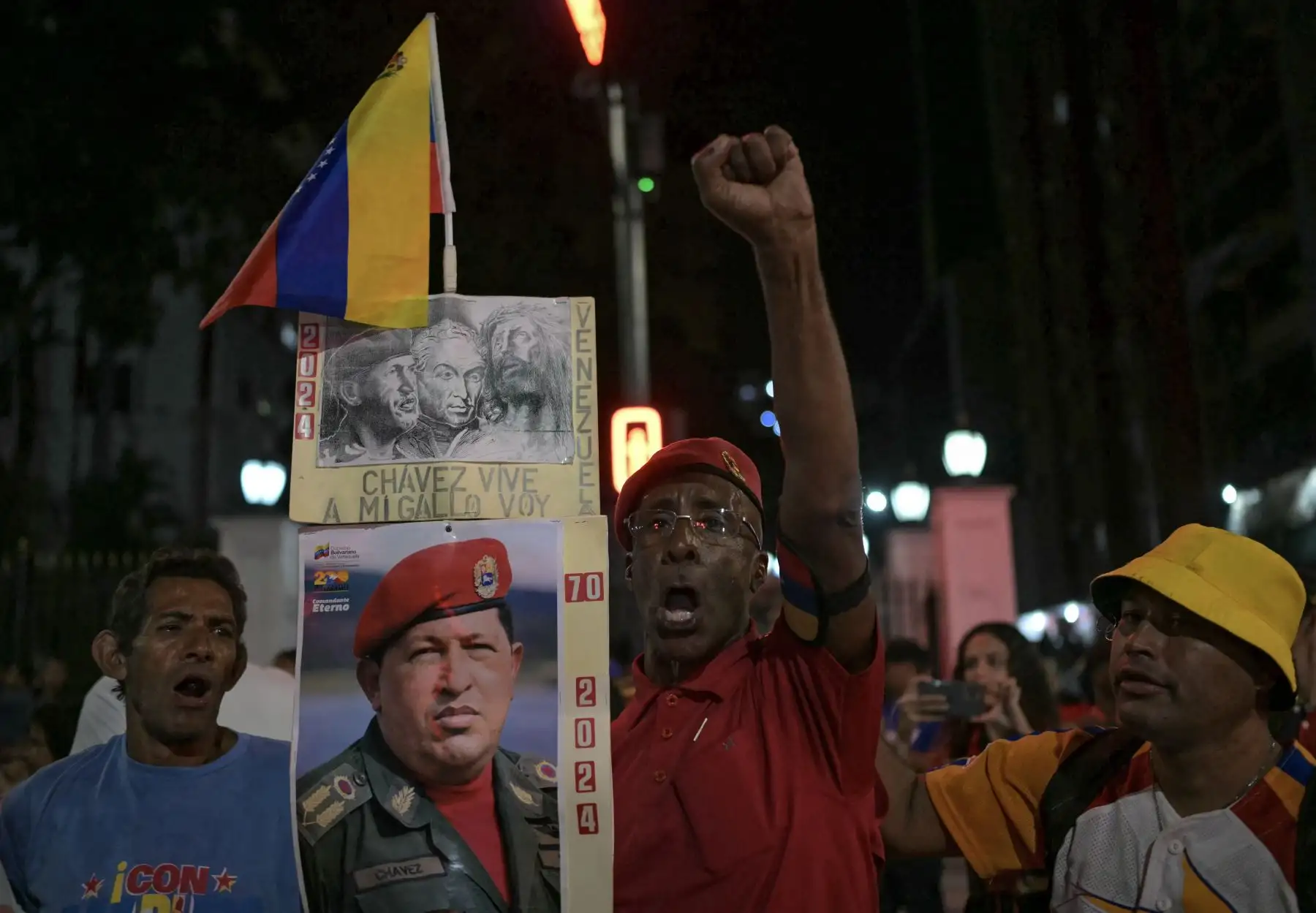 Un partidario con un cartel que representa al difunto presidente venezolano Hugo Chávez anima durante la celebración del presidente venezolano y candidato presidencial Nicolás Maduro después de conocer los resultados de las elecciones presidenciales, en Caracas. AFP