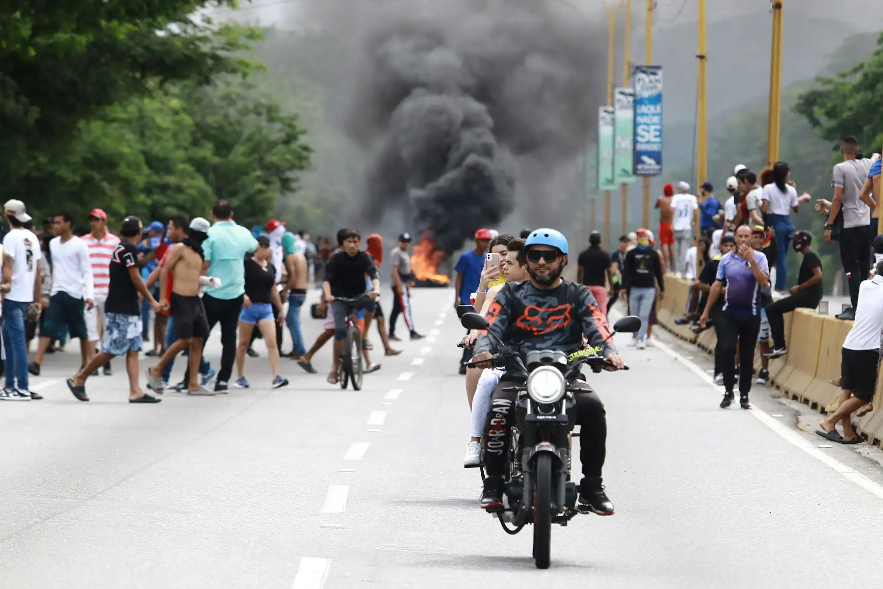 Se muestra a personas cerca de una barricada en llamas durante una protesta contra el gobierno del presidente venezolano Nicolás Maduro en Valencia, estado de Carabobo, Venezuela.
Foto: AFP