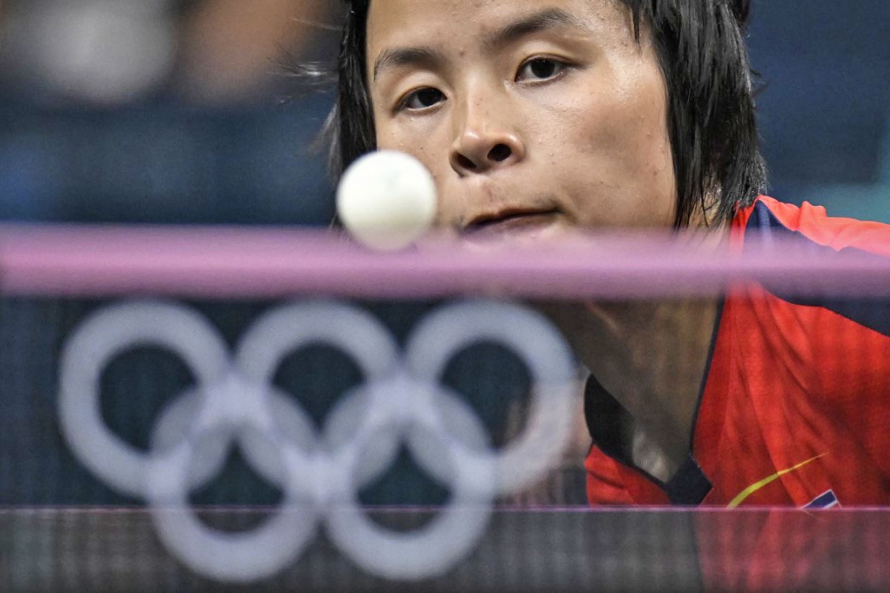 Pyon Song Gyong, de Corea del Norte, mira el balón mientras juega su regreso ante la alemana Nina Mittelham durante los dieciseisavos de final de individuales de tenis de mesa femenino en los Juegos Olímpicos de París 2024. Foto: AFP