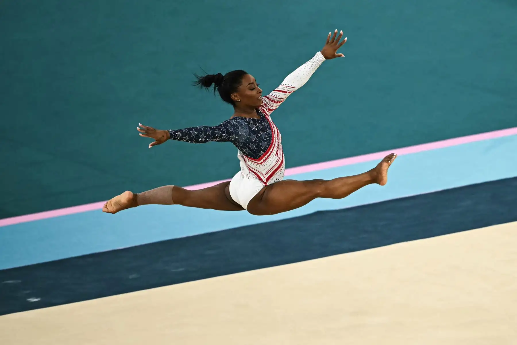 La estadounidense Simone Biles compite en la prueba de suelo de la final por equipos femenina de gimnasia artística durante los Juegos Olímpicos de París 2024. 
Foto: ANDINA/AFP