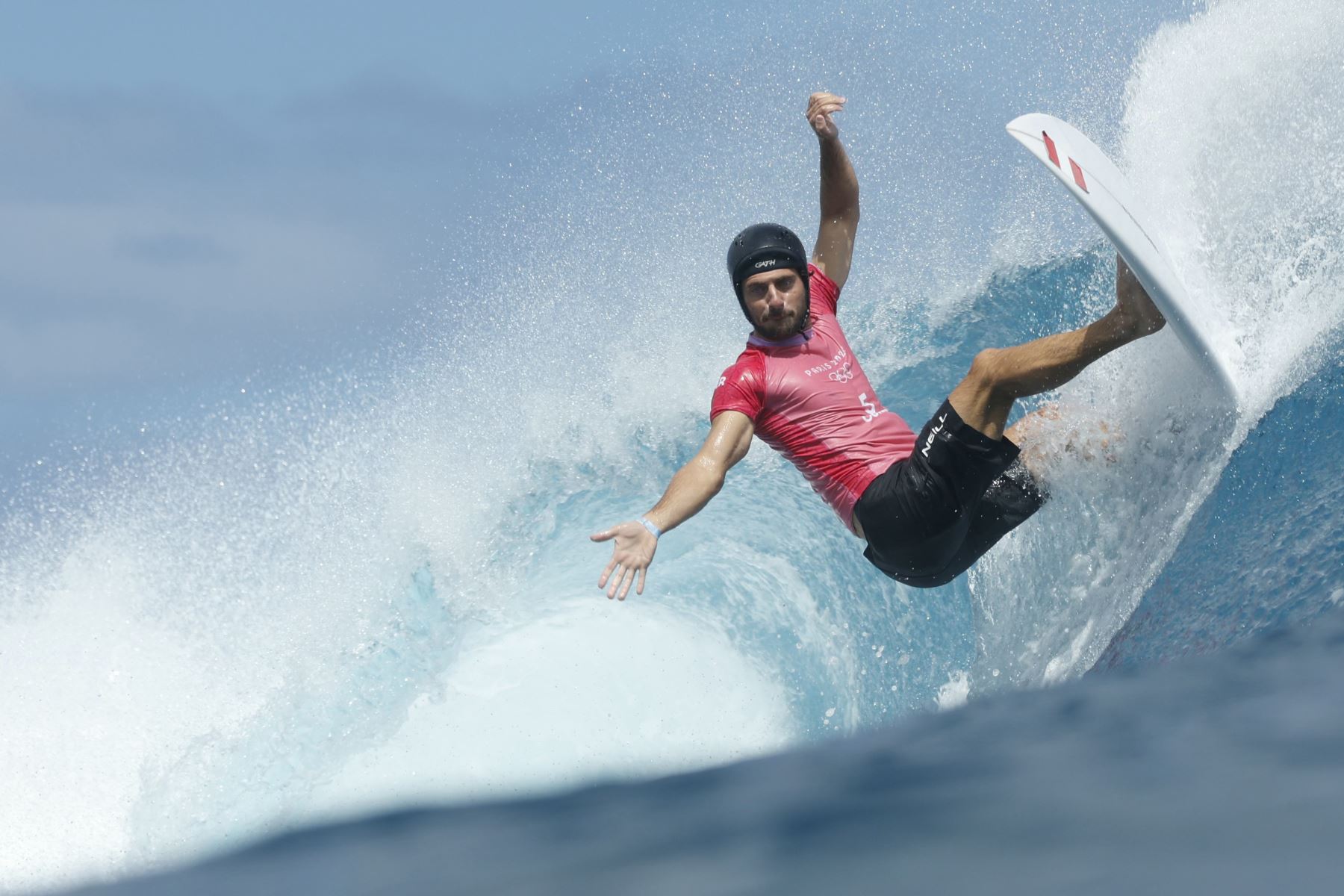 El peruano Alonso Correa corre por la cima de la ola en las eliminatorias de los cuartos de final de surf masculino, durante los Juegos Olímpicos de París 2024, en Teahupo