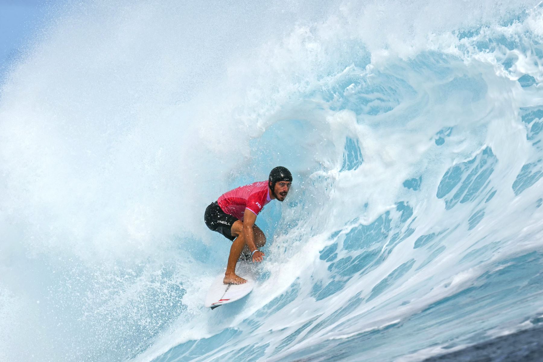 El peruano Alonso Correa corre una ola por dentro de manera tubular en las eliminatorias de los cuartos de final de surf masculino, durante los Juegos Olímpicos de París 2024, en Teahupo