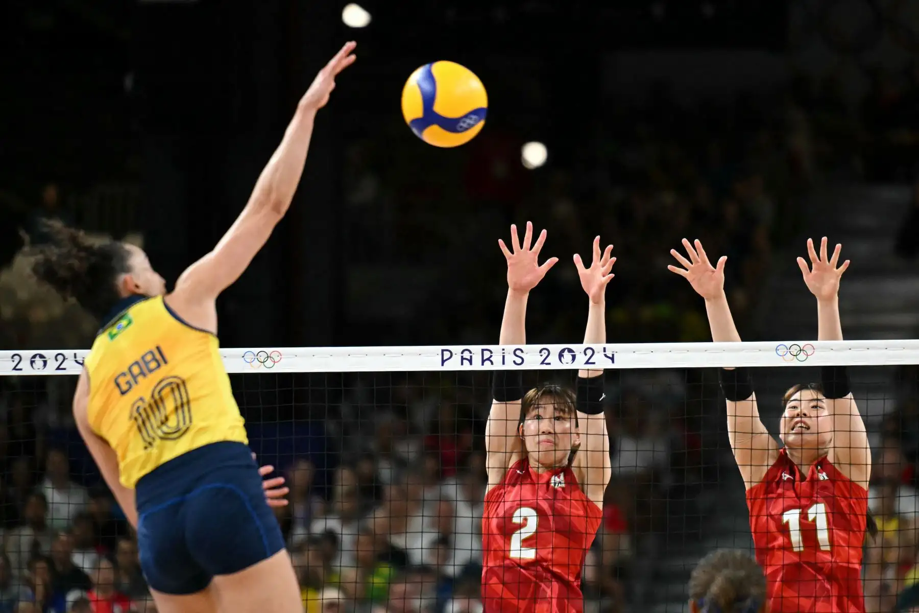 La japonesa Kotona Hayashi y la japonesa Nichika Yamada saltan para bloquear el balón de la brasileña Gabriela Braga Guimaraes durante el partido de voleibol de la ronda preliminar femenina entre Brasil y Japón durante los Juegos Olímpicos de París 2024 en el South Paris Arena 1 en París el 1 de agosto. Foto: AFP