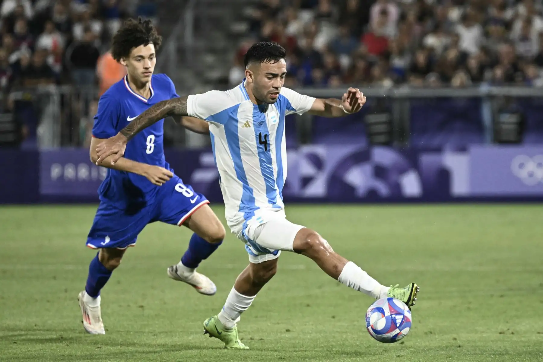 El defensor argentino  Joaquín García controla el balón frente al mediocampista francés  Maghnes Akliouche en el partido de fútbol masculino de cuartos de final entre Francia y Argentina durante los Juegos Olímpicos de París 2024. AFP