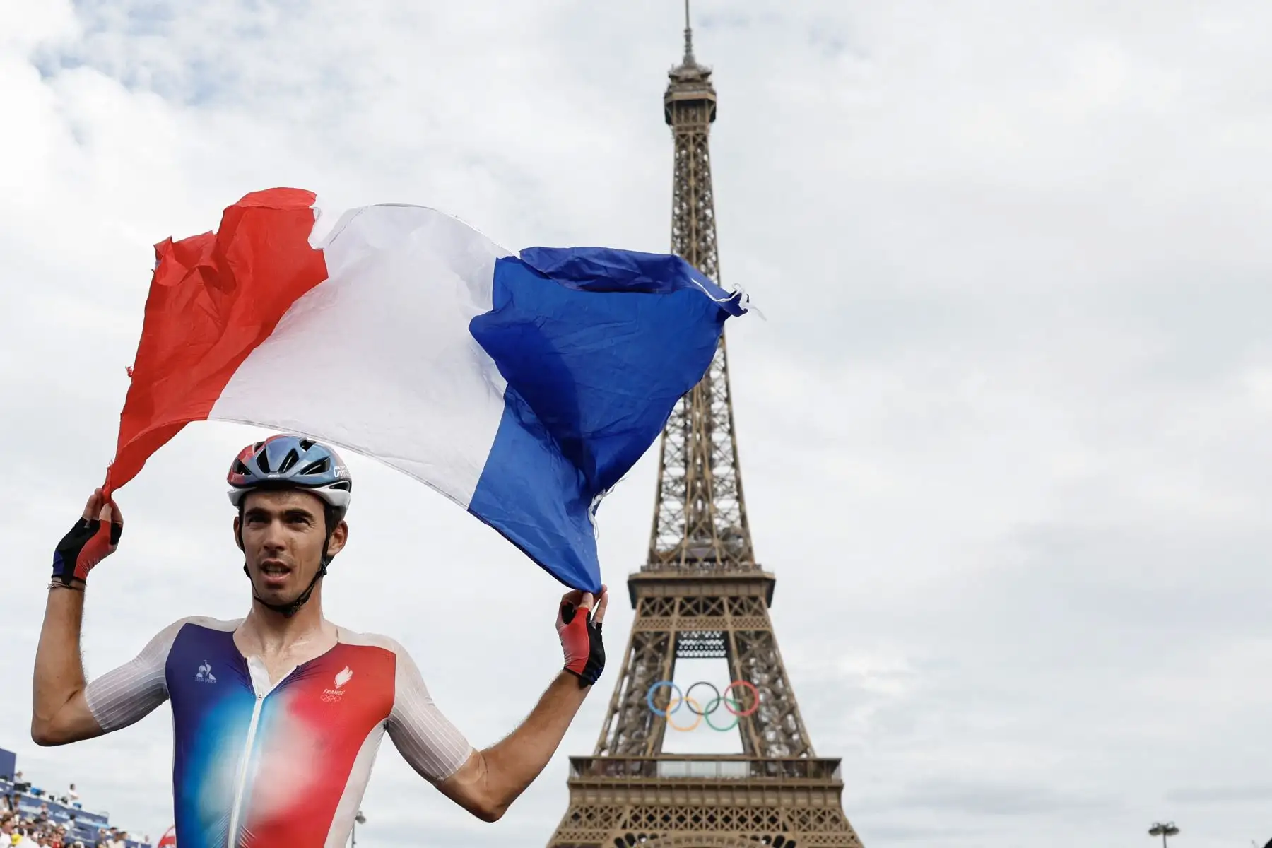 Christophe Laporte, de Francia, muestra una bandera francesa mientras celebra su tercera medalla de bronce después de la carrera ciclista masculina en ruta durante los Juegos Olímpicos de París 2024. AFP