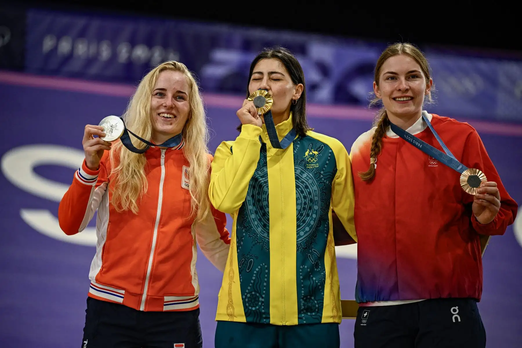 La ganadora de oro, la australiana  Saya Sakakibara , la subcampeona holandesa  Manon Veenstra y la ganadora de bronce, la suiza #02 Zoe Claessens  celebran en el podio después de la final de carreras de BMX de ciclismo femenino durante París 2024. Juegos olímpicos. AFP