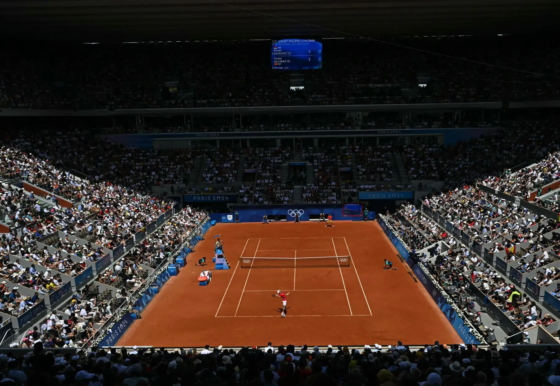 Los espectadores ven al español Carlos Alcaraz jugar contra el serbio Novak Djokovic durante su último partido de tenis masculino en la cancha Philippe-Chatrier del estadio Roland-Garros durante los Juegos Olímpicos de París 2024. AFP