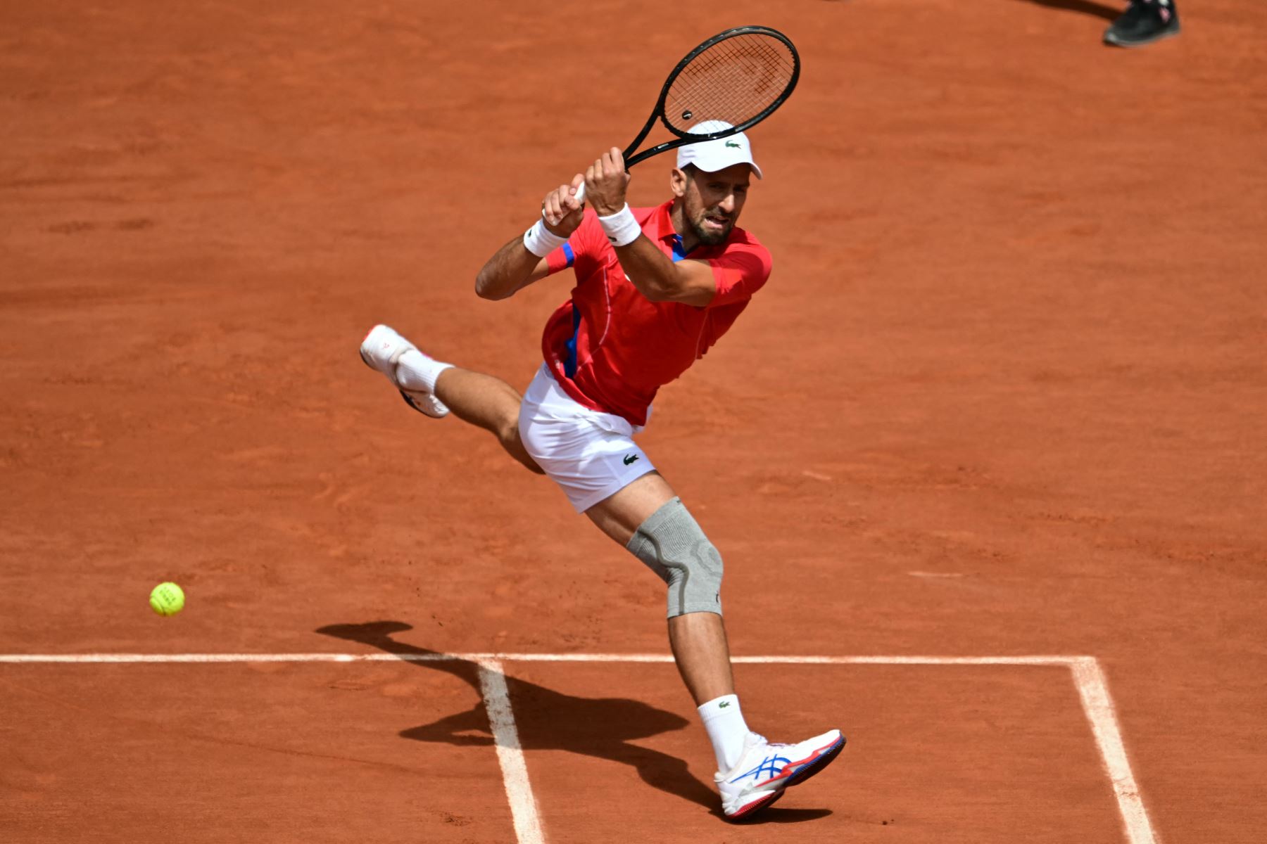 El serbio Novak Djokovic regresa al español Carlos Alcaraz durante su último partido de tenis masculino en la cancha Philippe-Chatrier del estadio Roland-Garros durante los Juegos Olímpicos de París 2024. AFP