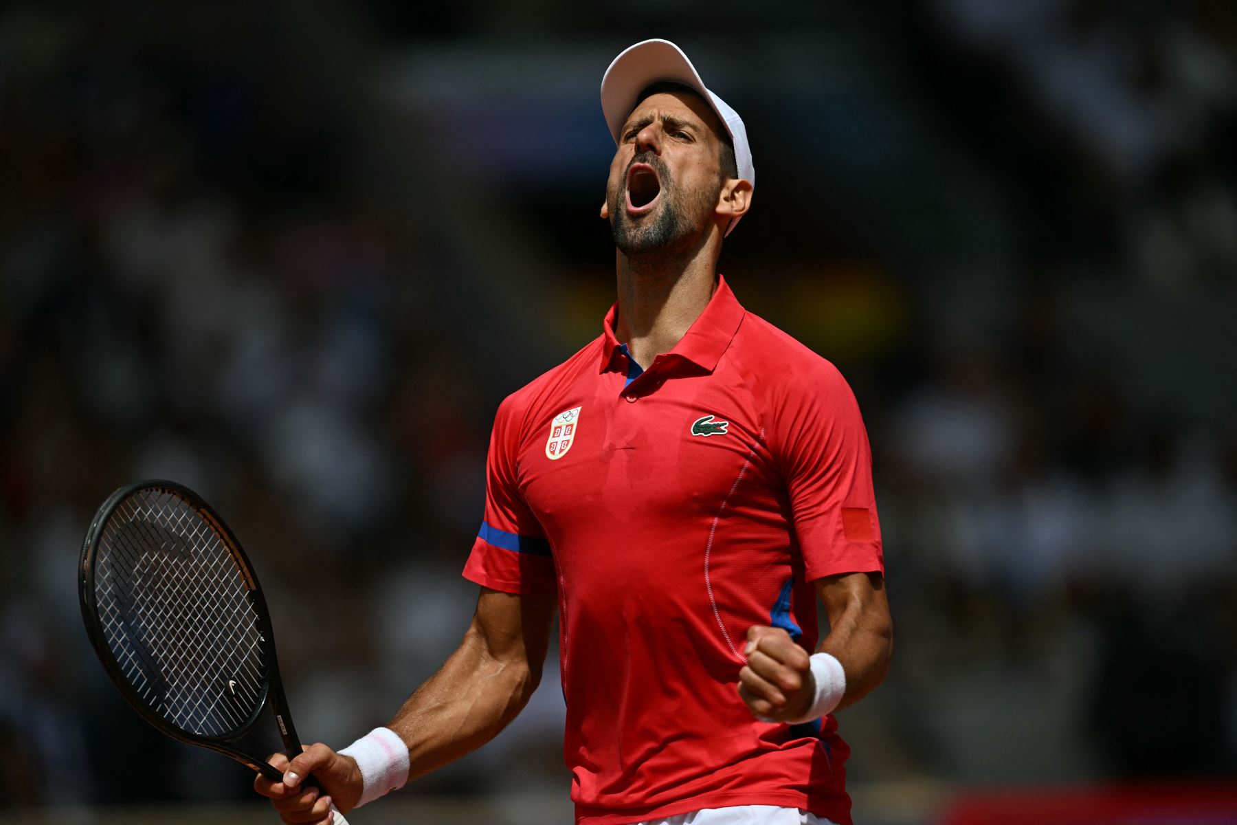 El serbio Novak Djokovic reacciona mientras juega contra el español Carlos Alcaraz durante su último partido de tenis masculino en la cancha Philippe-Chatrier del estadio Roland-Garros durante los Juegos Olímpicos de París 2024. AFP