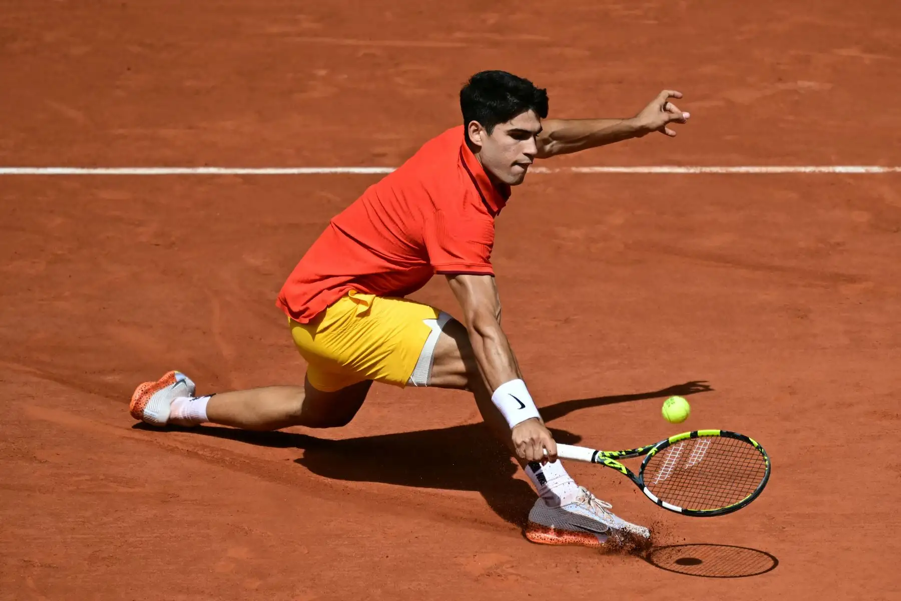 El español Carlos Alcaraz regresa al serbio Novak Djokovic durante su último partido de tenis masculino en la cancha Philippe-Chatrier del estadio Roland-Garros durante los Juegos Olímpicos de París 2024. AFP