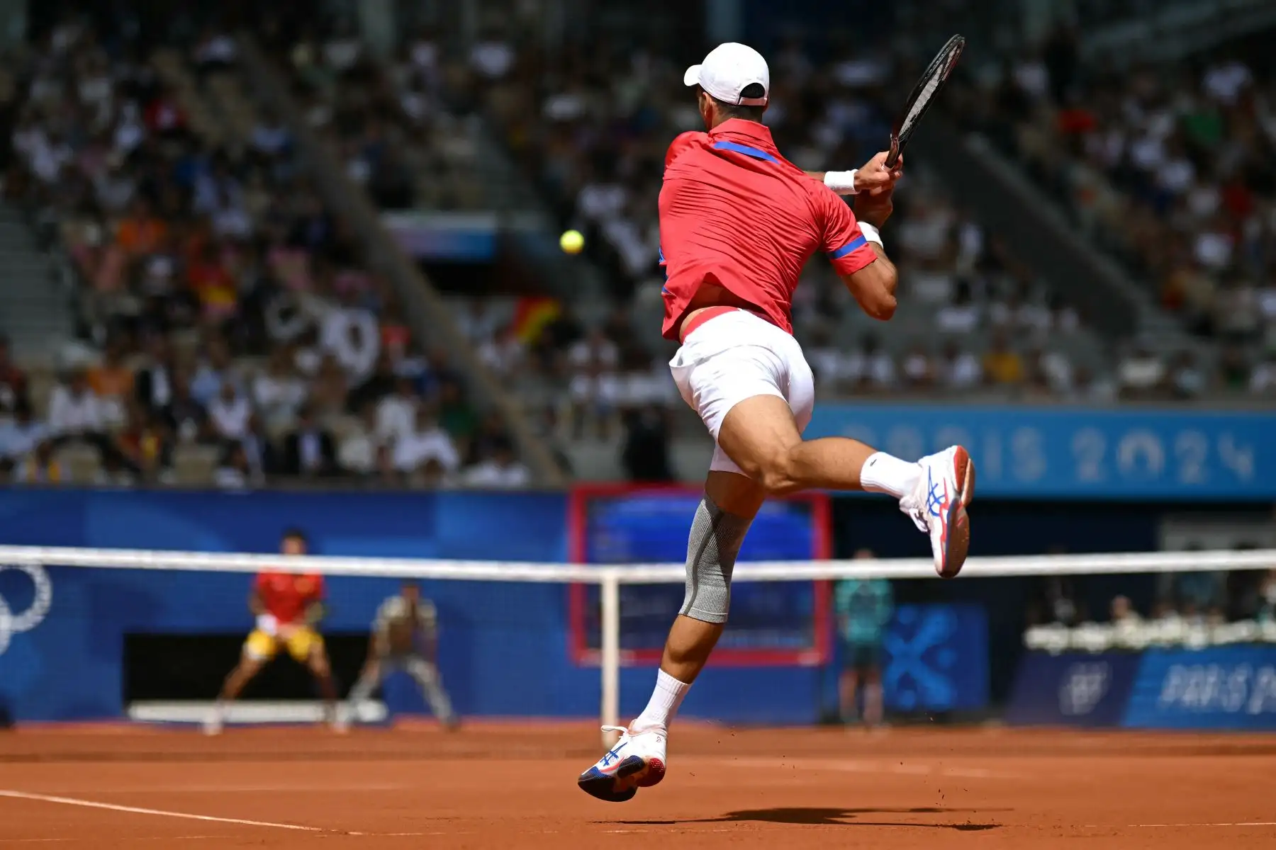 El serbio Novak Djokovic regresa al español Carlos Alcaraz durante su último partido de tenis masculino en la cancha Philippe-Chatrier del estadio Roland-Garros durante los Juegos Olímpicos de París 2024. AFP