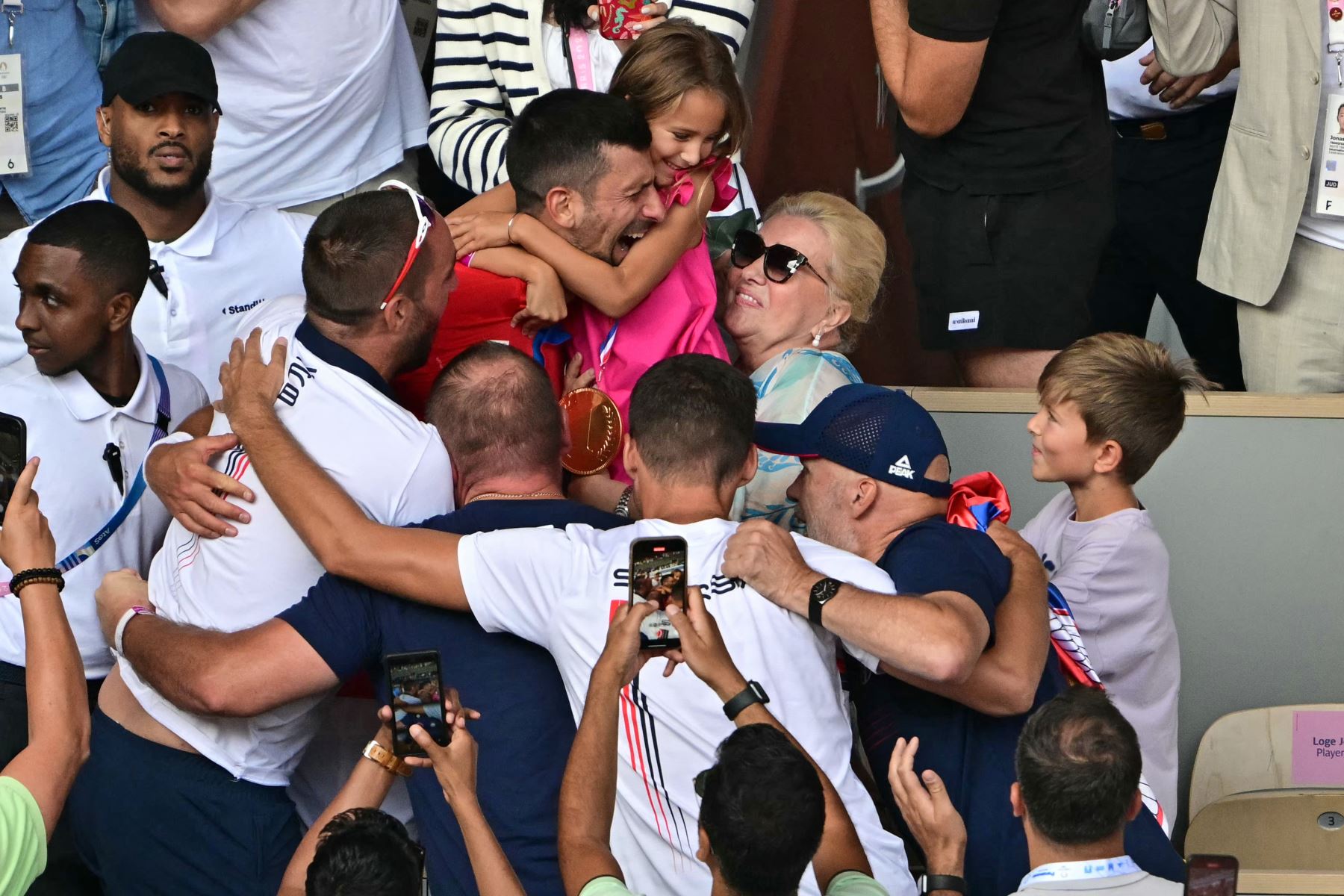 El serbio Novak Djokovic celebra con su familia entre la multitud después de vencer al español Carlos Alcaraz en la final masculina de tenis en la cancha Philippe-Chatrier del estadio Roland-Garros durante los Juegos Olímpicos de París 2024. AFP