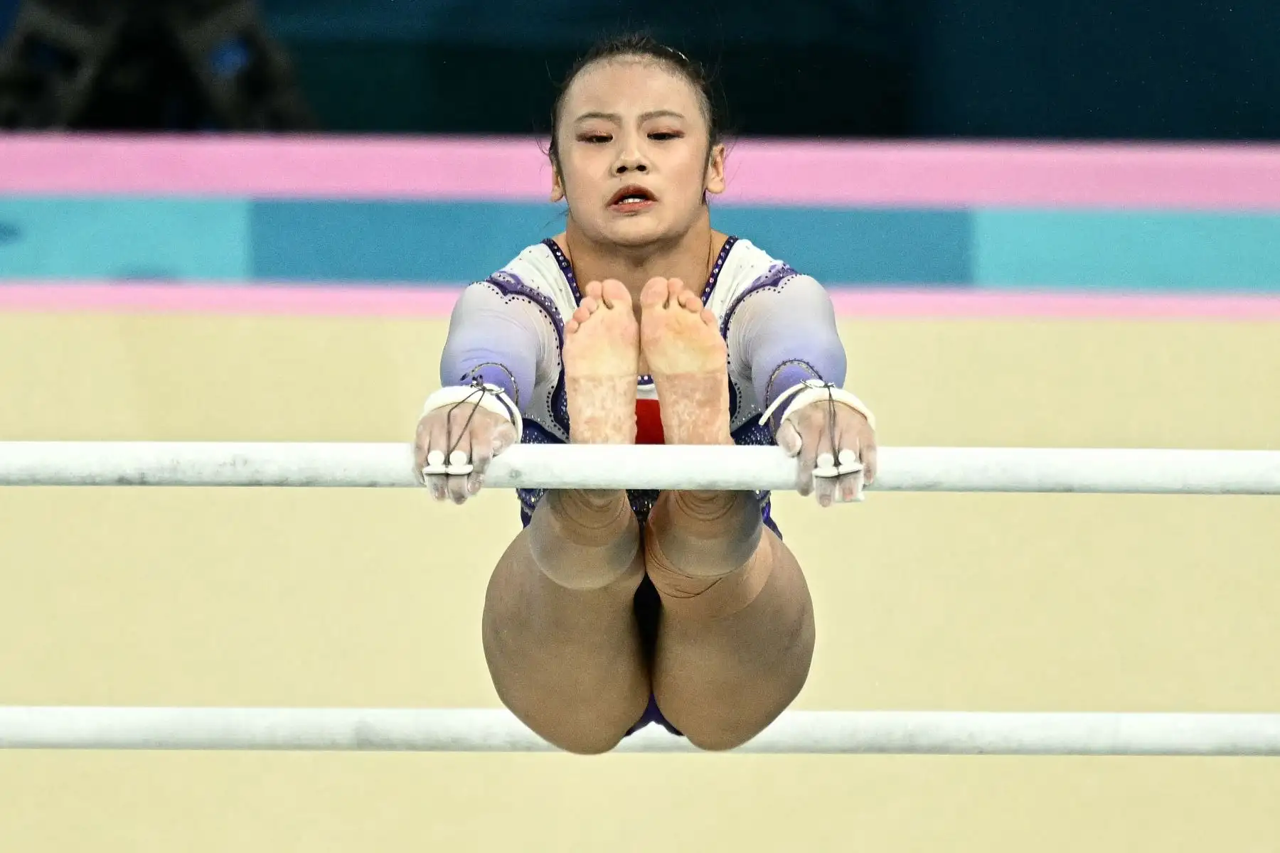 La china Qiu Qiyuan compite en la final de barras asimétricas femeninas de gimnasia artística durante los Juegos Olímpicos de París 2024 en el Bercy Arena de París.
Foto: AFP