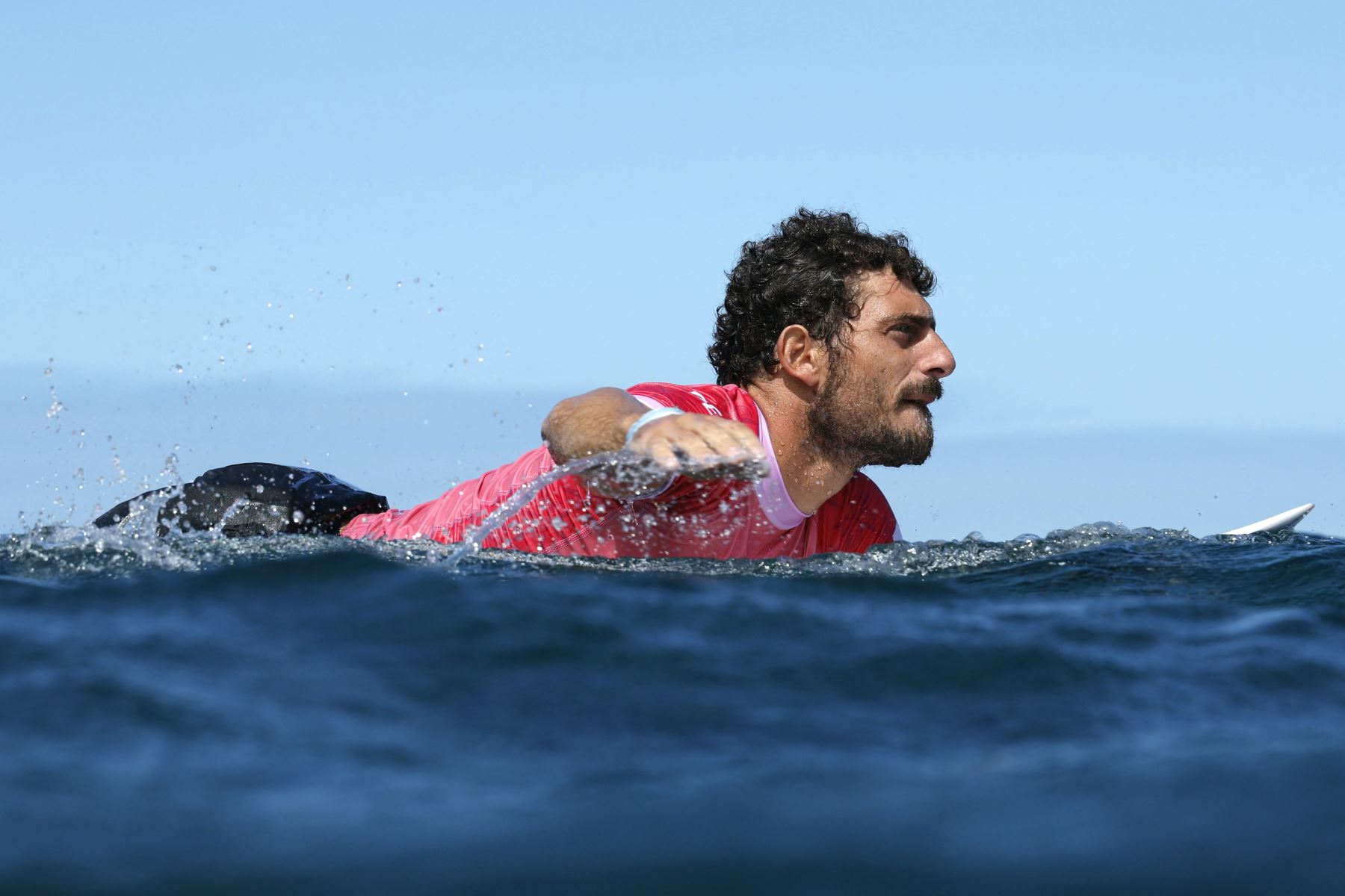 El peruano Alonso Correa rema en las semifinales masculinas de surf, durante los Juegos Olímpicos de París 2024, en Teahupo