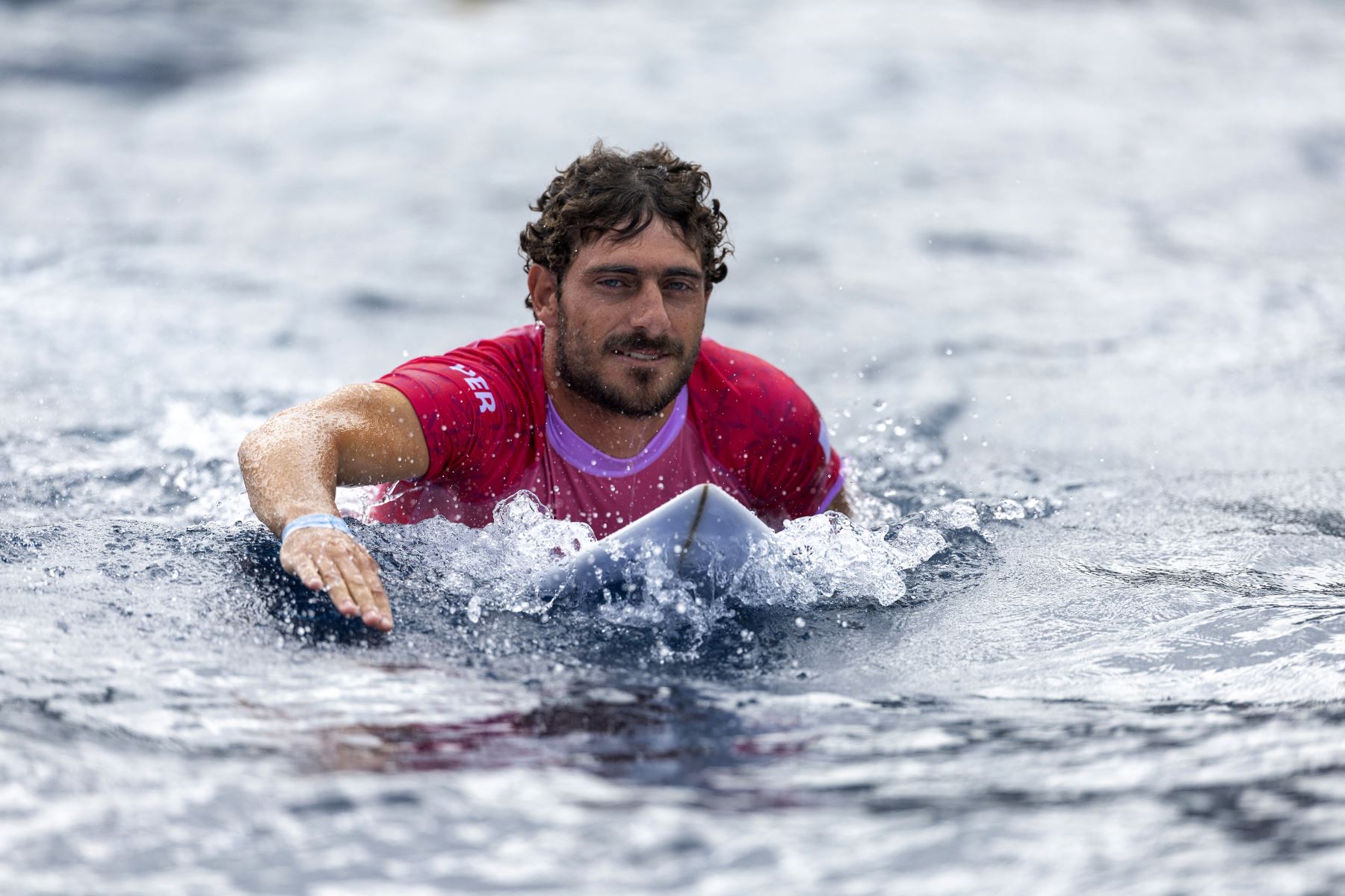 El peruano Alonso Correa rema en la final masculina por la medalla de bronce en surf, durante los Juegos Olímpicos de París 2024, en Teahupo