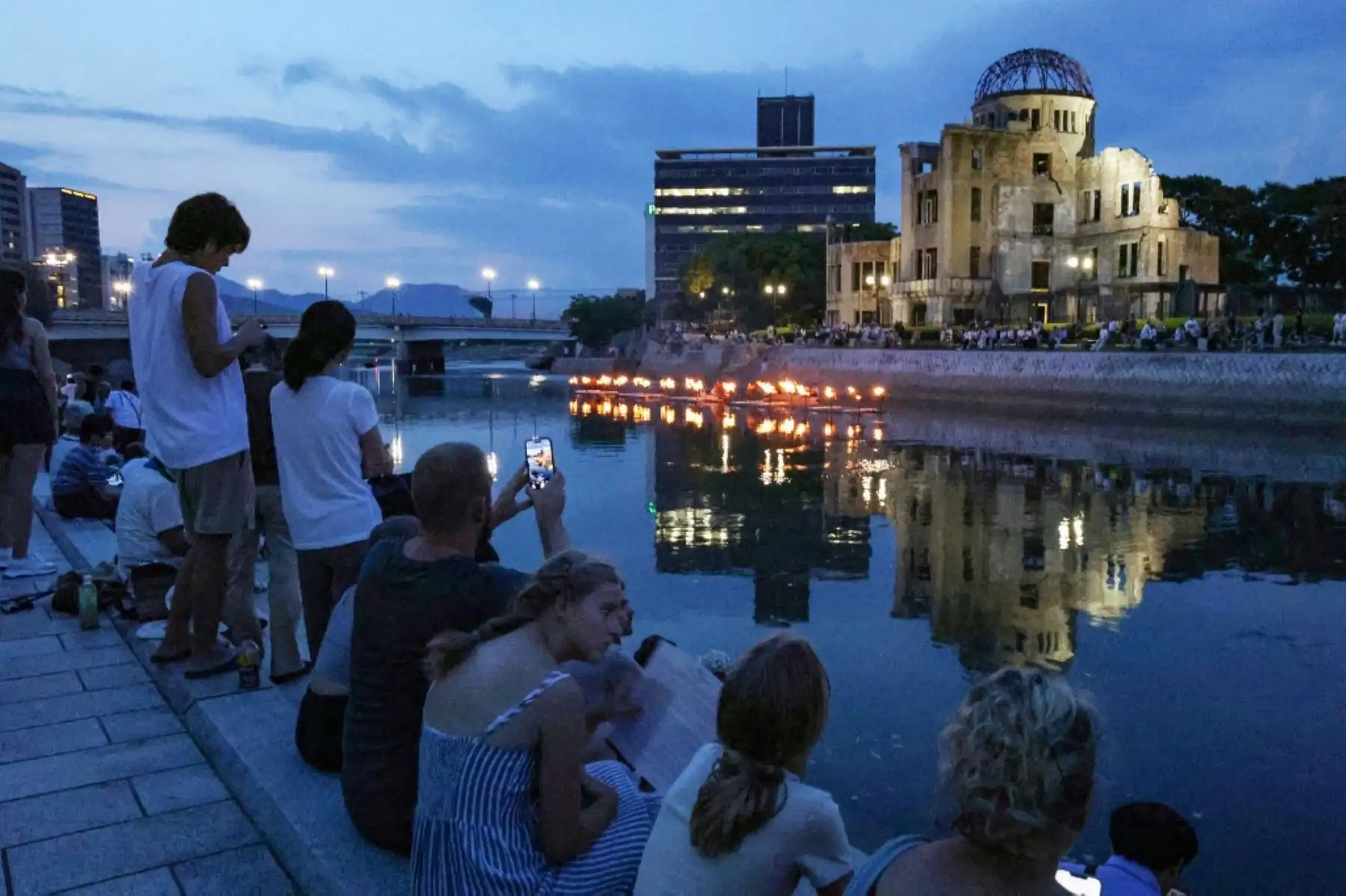 La gente asiste a una ceremonia conmemorativa a lo largo del río Motoyasu donde se encienden y colocan linternas en el río Motoyasu frente a la Cúpula de la Bomba Atómica en vísperas del 79.º aniversario del primer ataque con bomba atómica del mundo, en Hiroshima. Foto: AFP