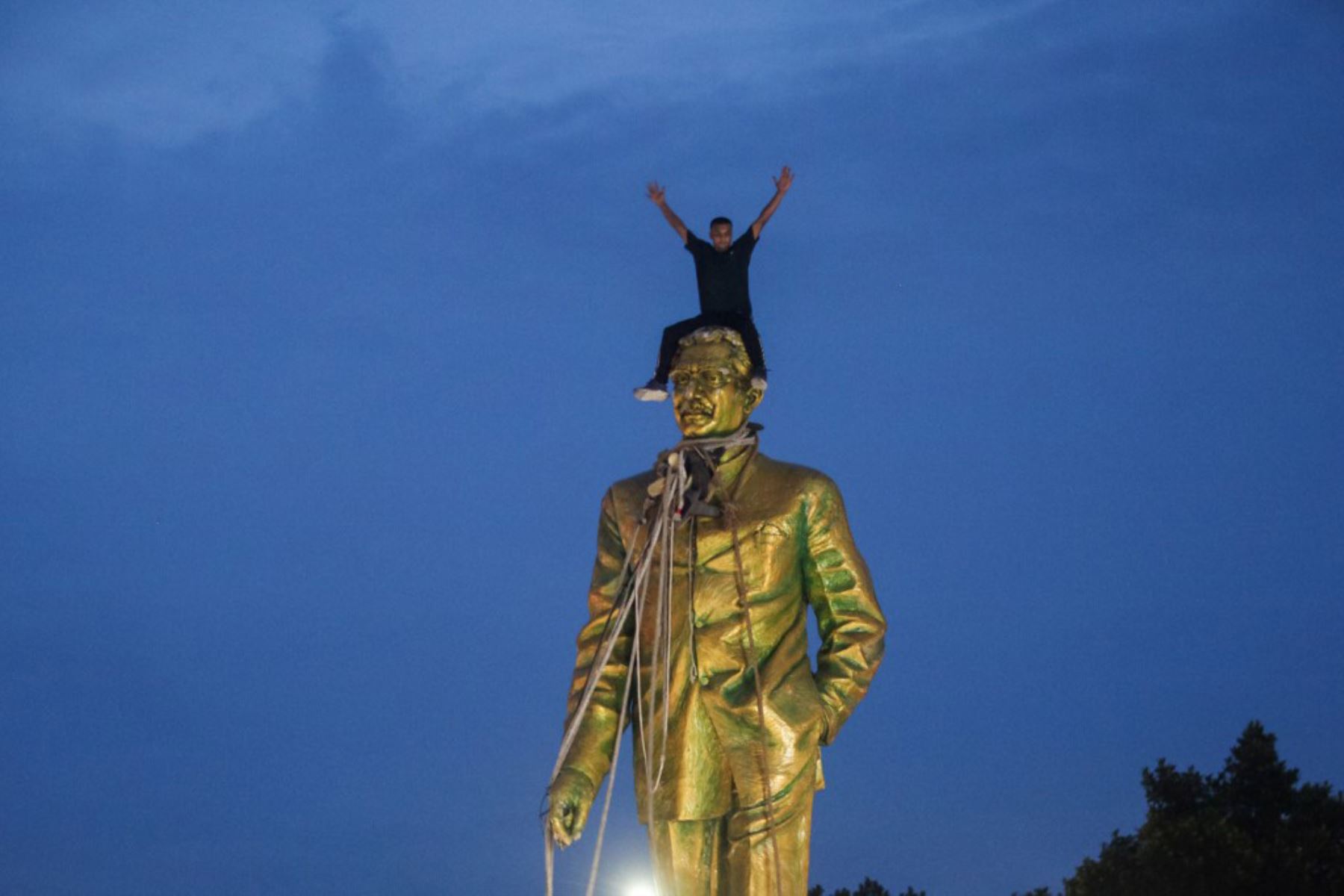 Un manifestante antigubernamental sube a una estatua de Sheikh Mujibur Rahman, padre fundador de Bangladesh y padre de la derrocada Primera Ministra del país, Sheikh Hasina, en Dhaka. Foto: AFP