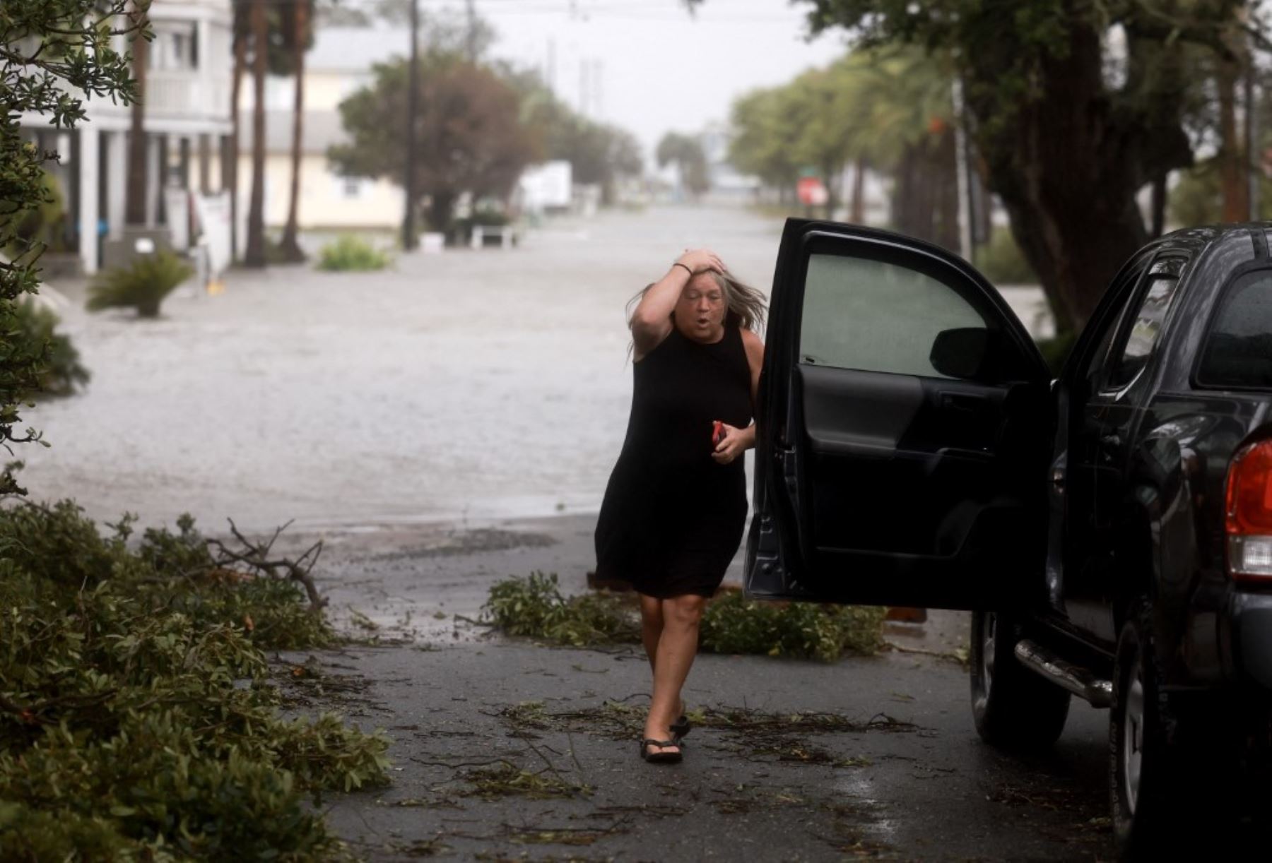 Una mujer vigila su vecindario mientras los fuertes vientos, la lluvia y la marejada ciclónica del huracán Debby inundan el área en Cedar Key, Florida. El huracán golpea  también con  fuertes vientos el área de Big Bend en Florida. Foto: AFP