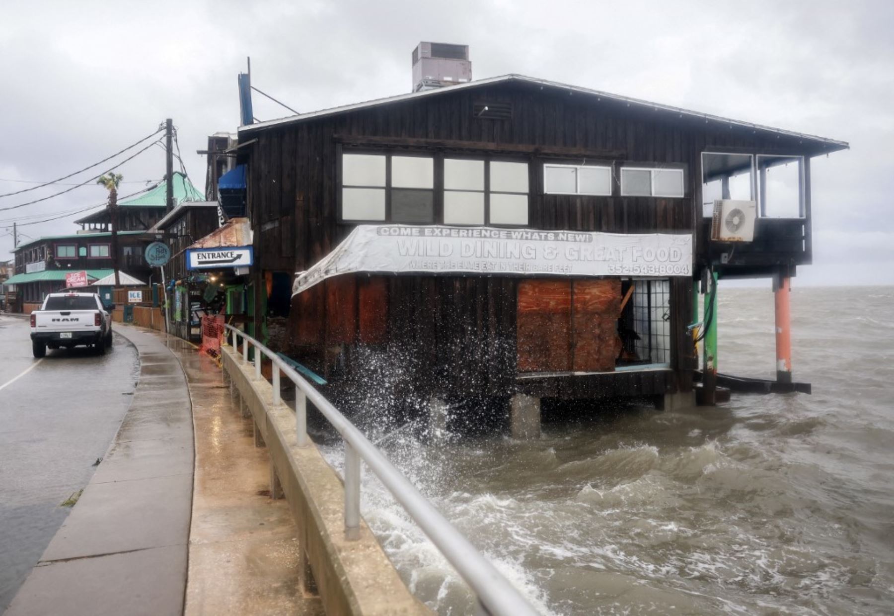 Los edificios que se encuentran a lo largo de la costa  soportan la lluvia y la marejada ciclónica del huracán Debby que inundan un vecindario  en Cedar Key, Florida. Foto: AFP