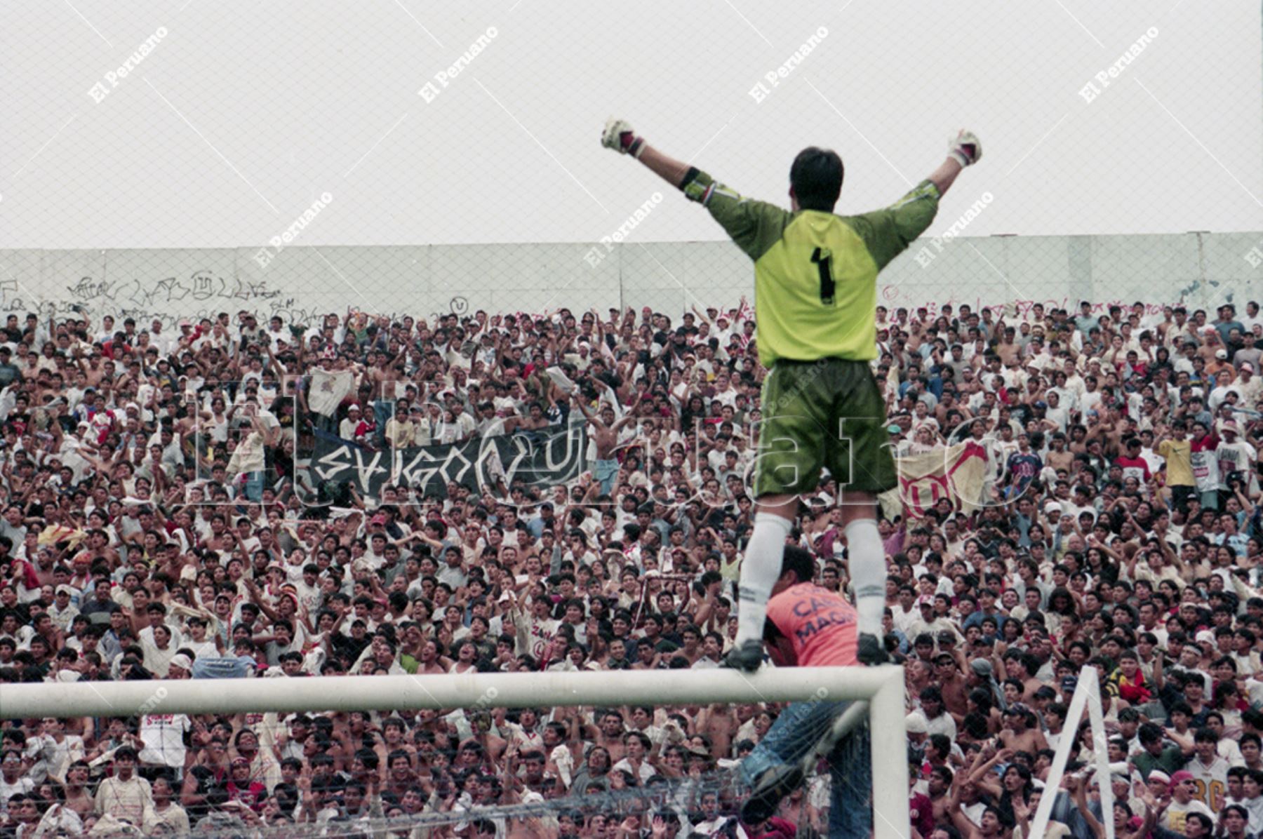 Lima - 20 diciembre 1999 / El arquero Óscar Ibáñez celebra trepado en el arco norte. Los jugadores de Universitario  de Deportes dieron la vuelta olímpica en el estadio de Alianza Lima. El cuadro crema se coronó bicampeón del fútbol peruano pese a perder 0-1 pues en el primer partido del play off  venció su clásico rival por 3-0. Foto: Archivo Histórico de El Peruano / Norman Córdova