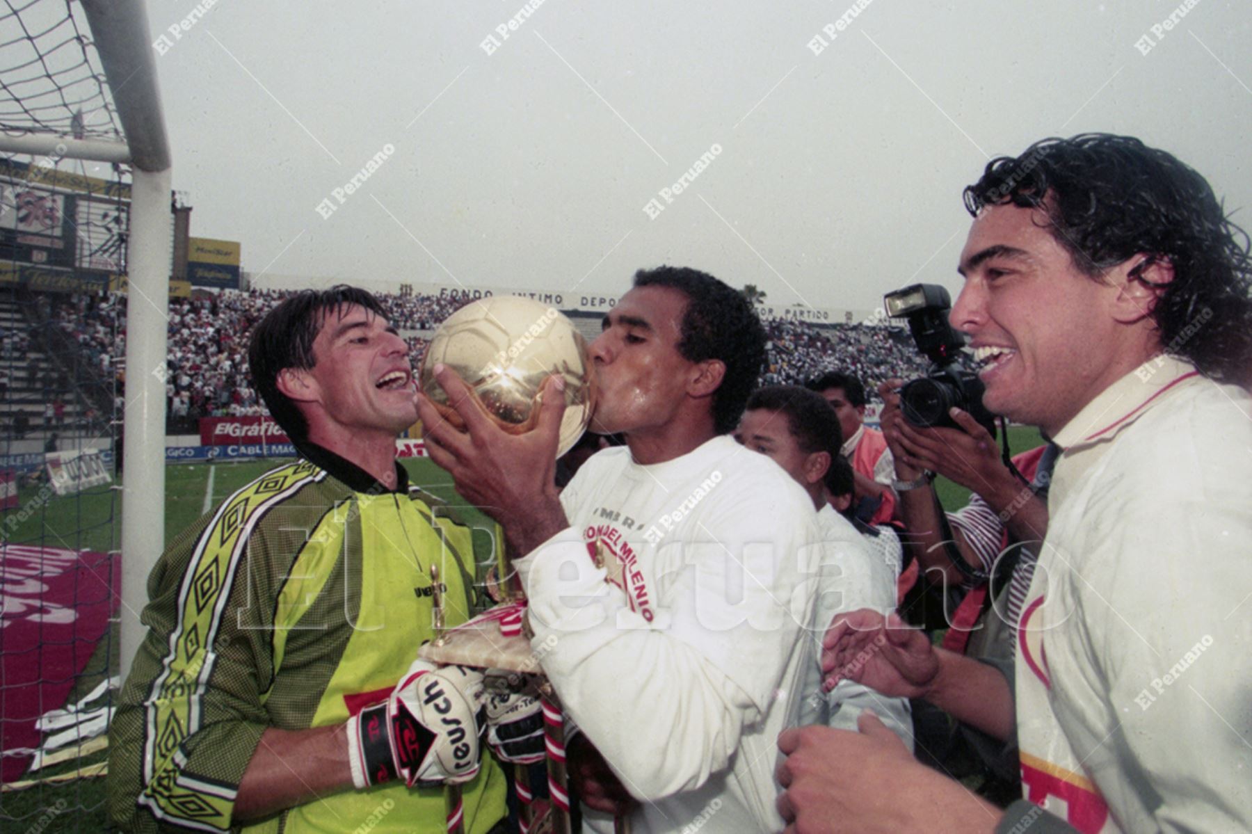 Lima - 20 diciembre 1999 / Gregorio Bernales besa el trofeo. Los jugadores de Universitario  de Deportes dan la vuelta olímpica en el estadio de Alianza Lima. El cuadro crema se coronó bicampeón del fútbol peruano pese a perder 0-1 pues en el primer partido del play off venció 3-0 a su clásico rival. Foto: Archivo Histórico de El Peruano / Jack Ramón