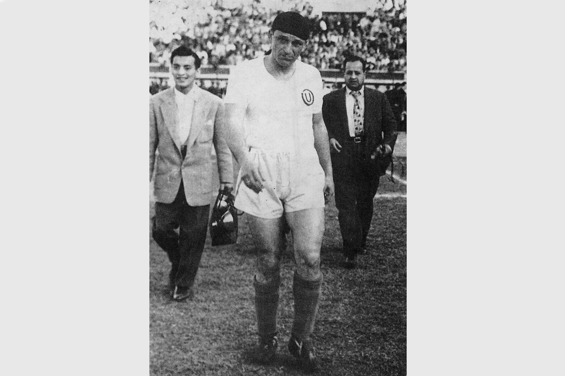 Lima - Década 1950 / Teodoro "Lolo" Fernández, gran cañonero de Universitario de Deportes, en el Estadio Nacional. Detrás aparecen José Risco y Abel Ego-Aguirre reporteros gráficos del diario La Crónica. Foto: Libro "Lolo, ídolo eterno"