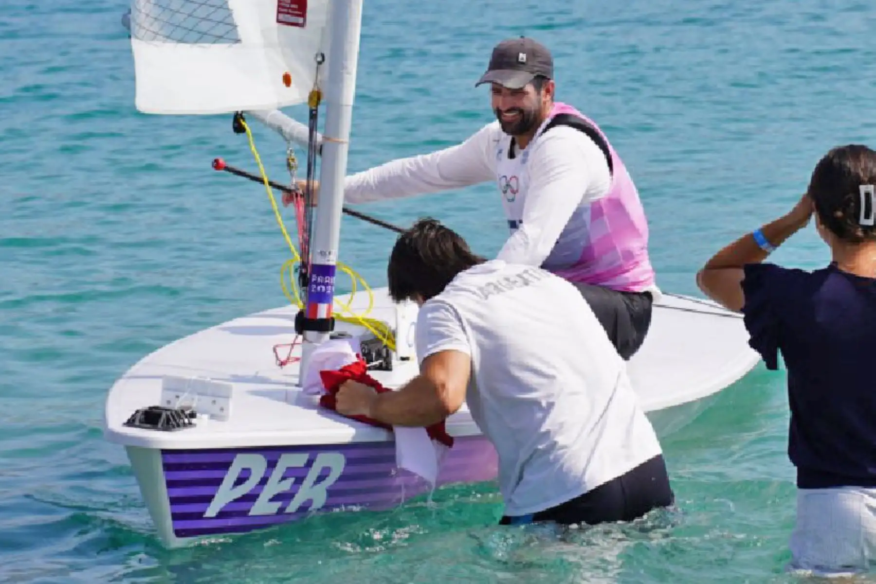 Stefano Peschiera celebra con la bandera peruana tras conquistar la medalla olímpica de bronce en vela, modalidad dinghy masculino, al ocupar el tercer lugar en la clasificación general en los Juegos Olímpicos de París 2024, en la competencia disputada en Marsella. Foto: Team Perú