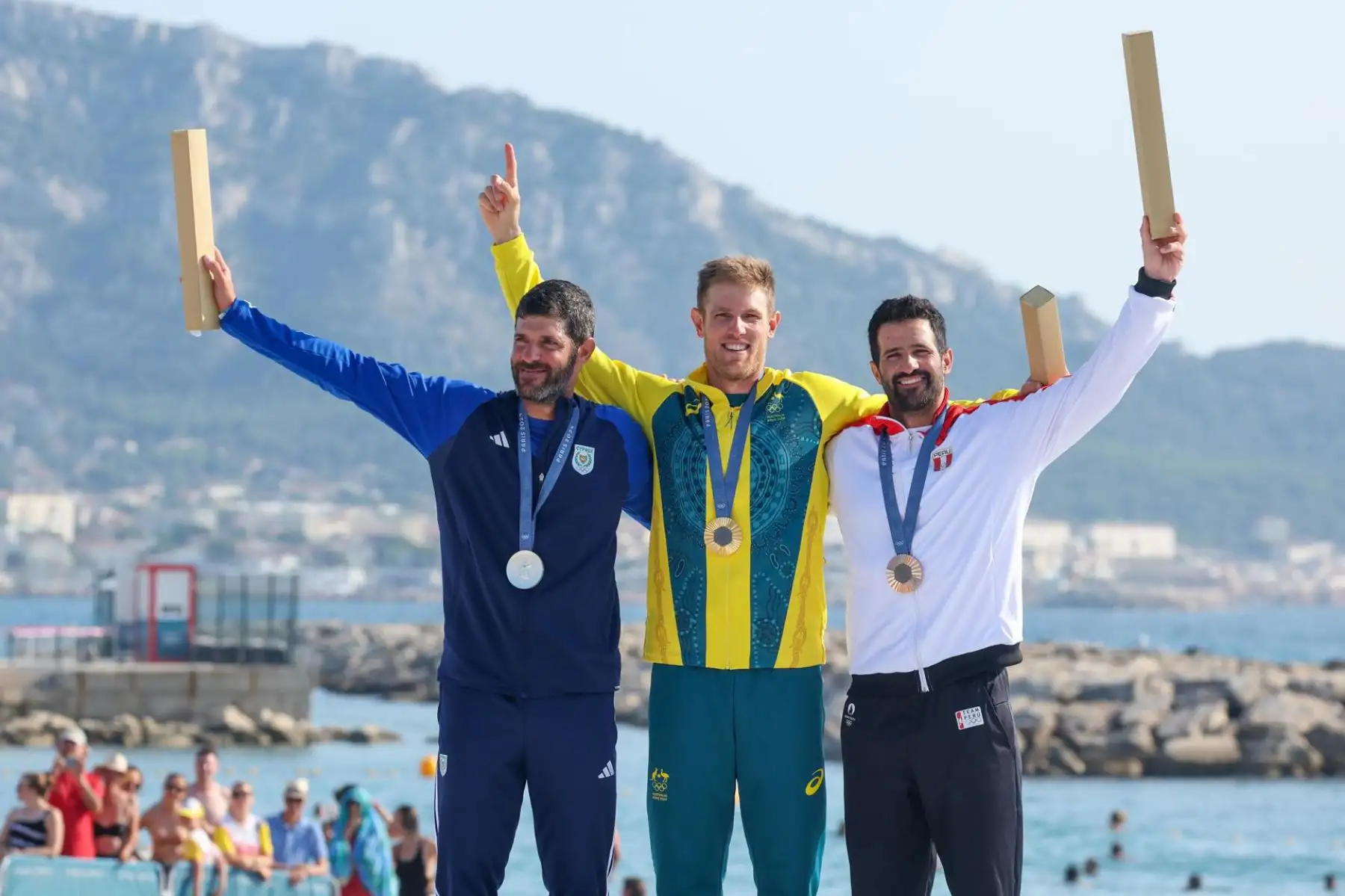 El medallista de plata Pavlos Kontides de Chipre, el medallista de oro Matt Wearn de Australia y el medallista de bronce Stefano Peschiera de Perú durante la ceremonia de entrega de medallas para el evento de vela ligera masculina de las competiciones de vela en los Juegos Olímpicos de París 2024, en la Marina de Marsella. Foto: AFP