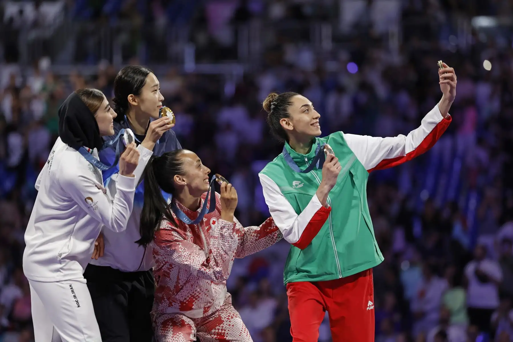 La medallista de plata Nahid Kiyanichanden de Irán, la medallista de oro Yuin Kim de Corea del Sur y las medallistas de bronce Skylar Park de Canadá y Kimia Alizadeh Zenozi de Bulgaria celebran en el podio durante la ceremonia de premiación de la categoría femenina de 57 kg de las competiciones de Taekwondo en los Juegos Olímpicos de París 2024. Foto: EFE