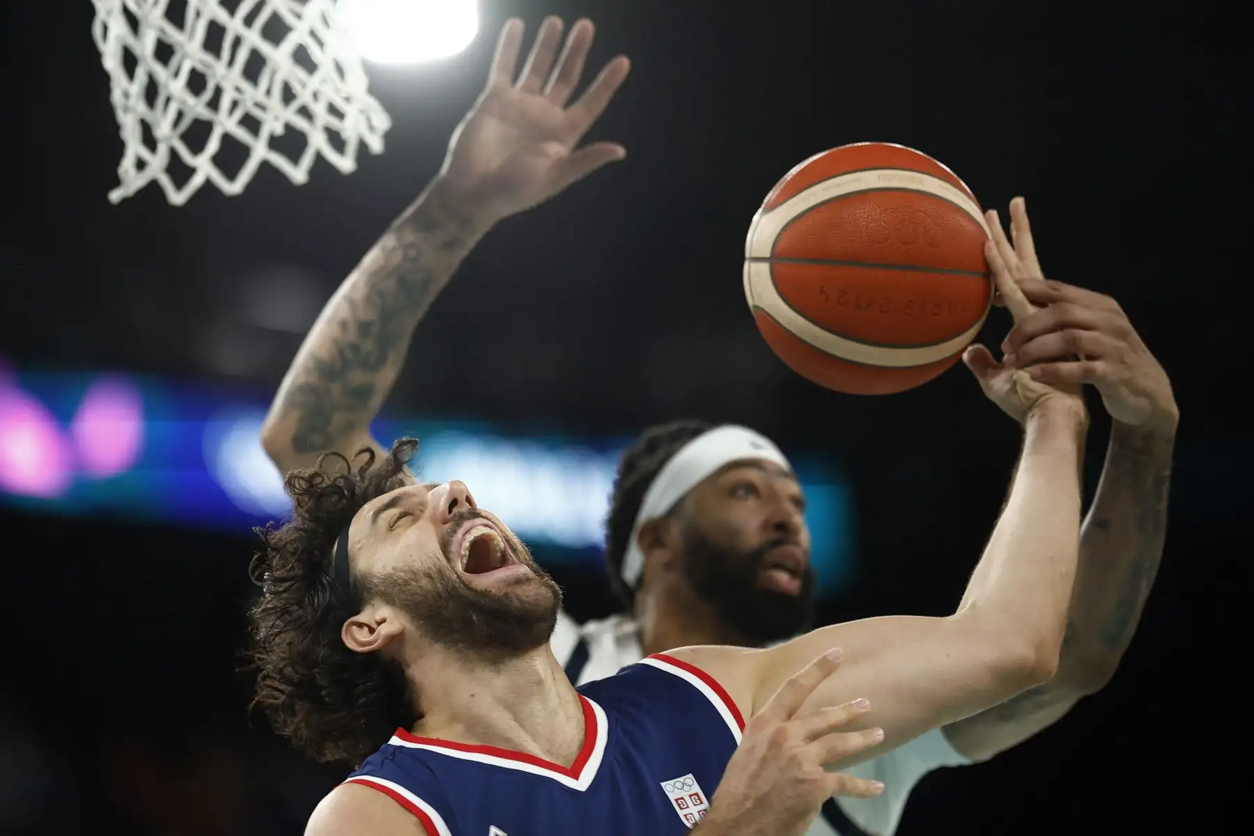 Vasilije Micic de Serbia y Anthony Davis de EE.UU. en acción durante el partido de semifinal masculina entre EE.UU. y Serbia en las competiciones de baloncesto de los Juegos Olímpicos de París 2024, en el South Paris Arena de Francia. Foto: EFE