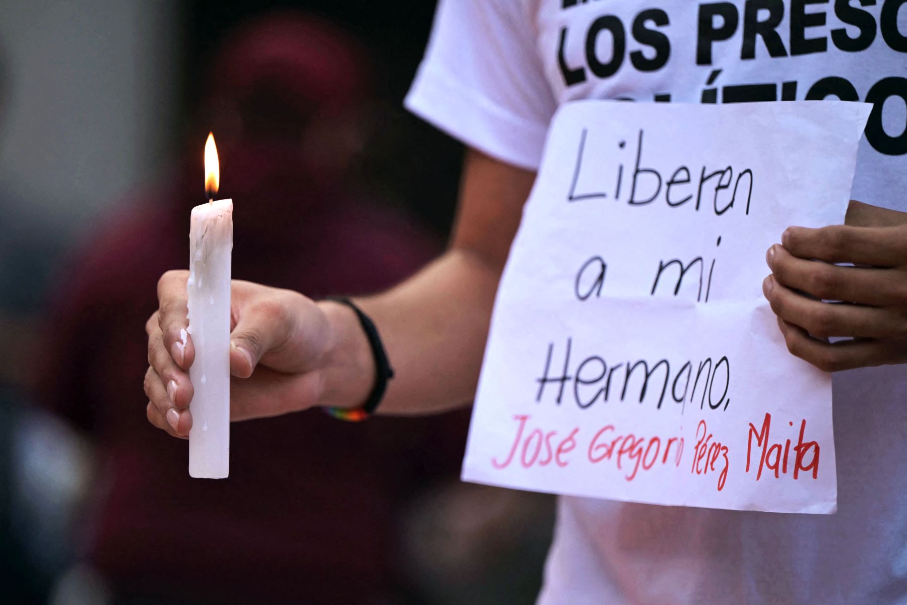 Un hombre sostiene una vela y un cartel pidiendo la liberación de su hermano durante una vigilia convocada por la oposición política en Caracas, Venezuela, exigiendo la libertad de los presos políticos arrestados durante las protestas tras la impugnada reelección del presidente Nicolás Maduro. Foto: AFP