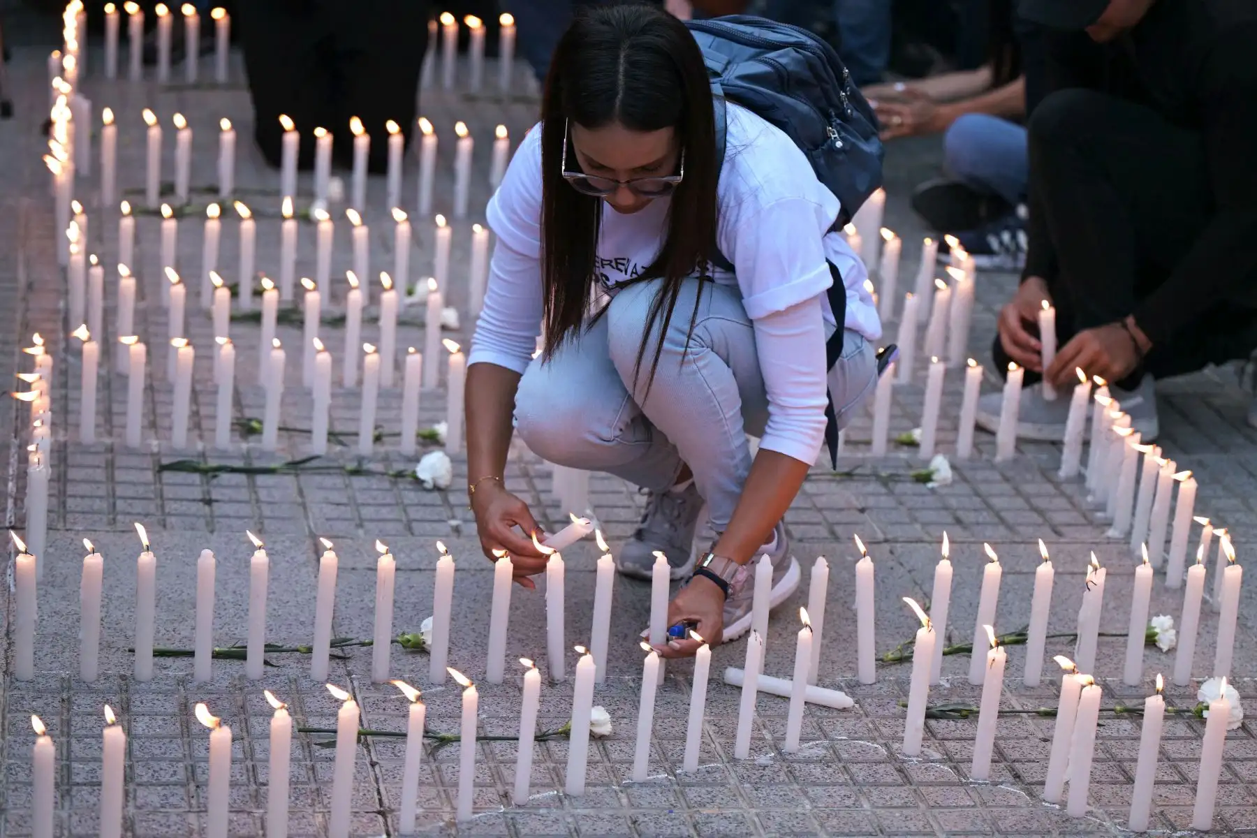 Una mujer joven enciende velas durante una vigilia convocada por la oposición política en Caracas, Venezuela, exigiendo la libertad de los presos políticos arrestados durante las protestas tras la impugnada reelección del presidente Nicolás Maduro. Foto: AFP