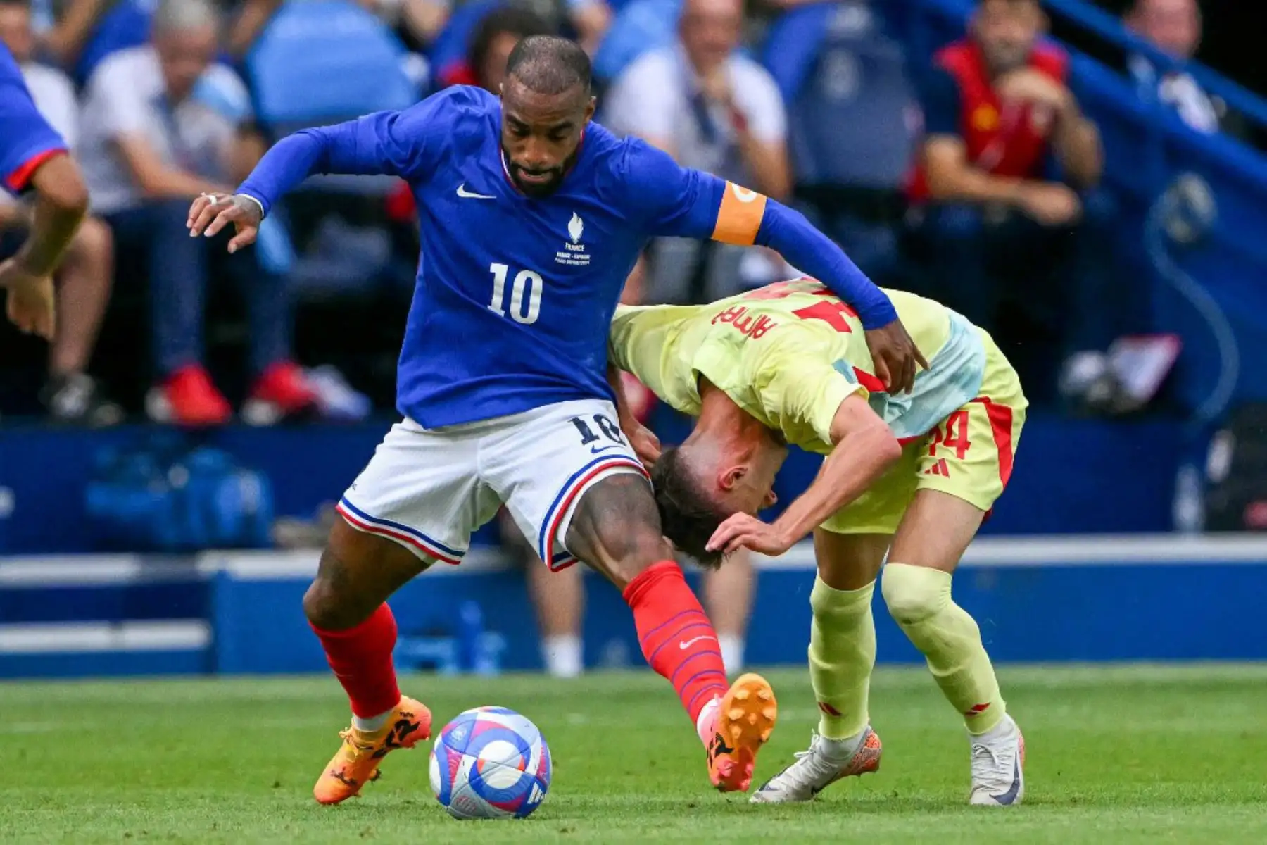 El delantero francés Alexandre Lacazette lucha por el balón con el centrocampista español Aimar Oroz en el partido de fútbol final por la medalla de oro masculina entre Francia y España durante los Juegos Olímpicos de París 2024 en el Parc des Princes de París. Foto: AFP