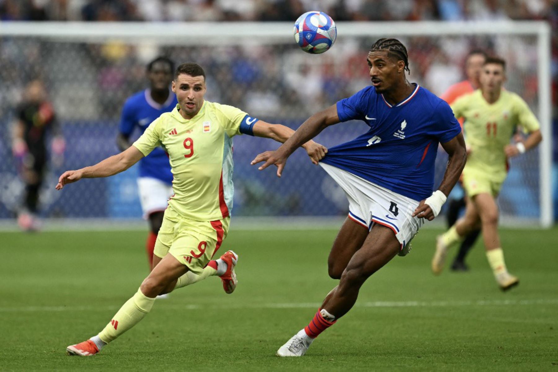 El delantero español Abel Ruiz agarra la camiseta del defensor francés Loic Bade en el partido de fútbol final por la medalla de oro masculina entre Francia y España durante los Juegos Olímpicos de París 2024 en el Parc des Princes de París el 9 de agosto de 2024. Foto: AFP