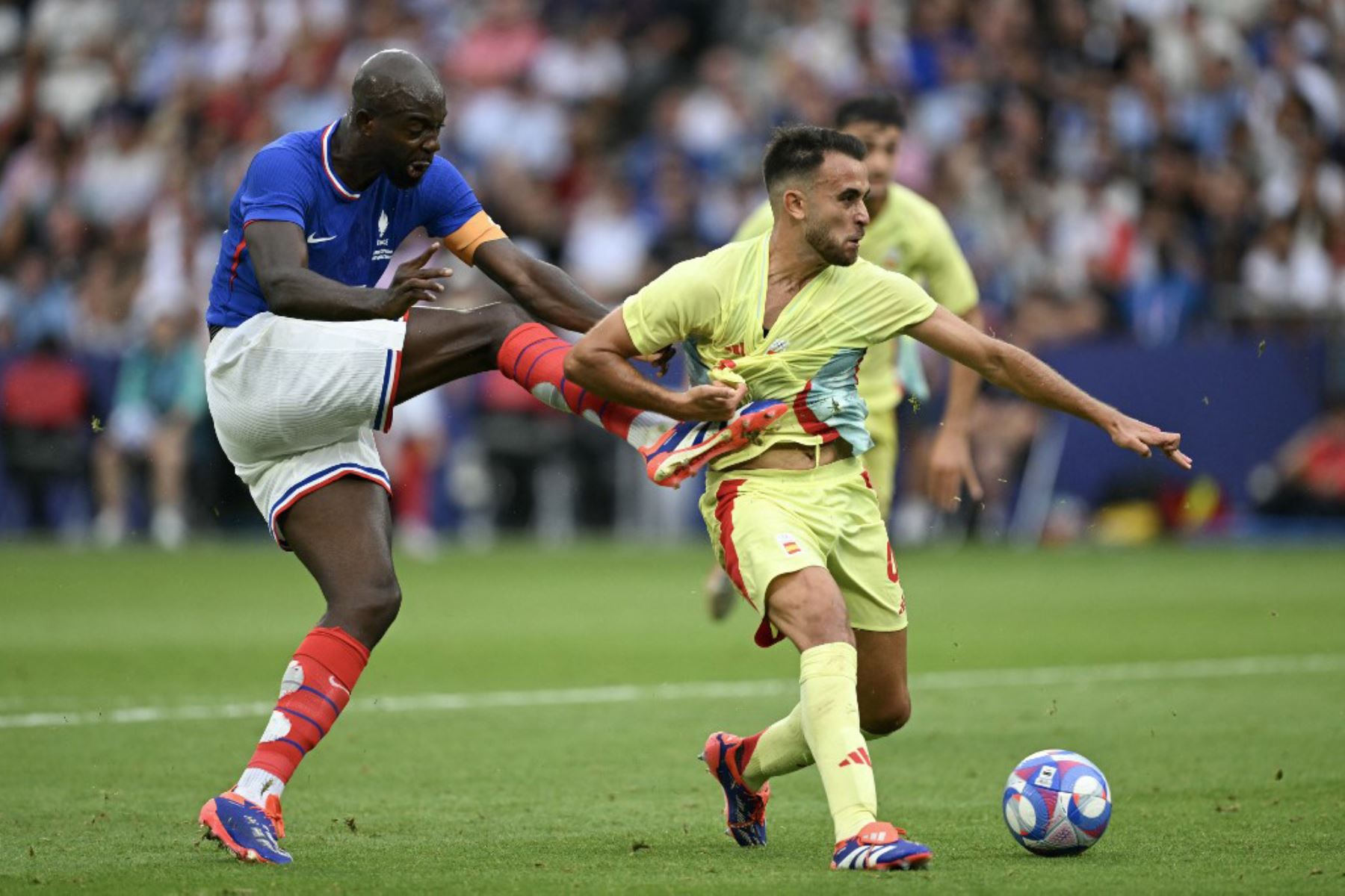 El delantero francés Jean-Philippe Mateta y el defensor español #04 Eric García compiten por el balón en el partido de fútbol final por la medalla de oro masculina entre Francia y España durante los Juegos Olímpicos de París 2024 en el Parque de los Príncipes de París. Foto: AFP