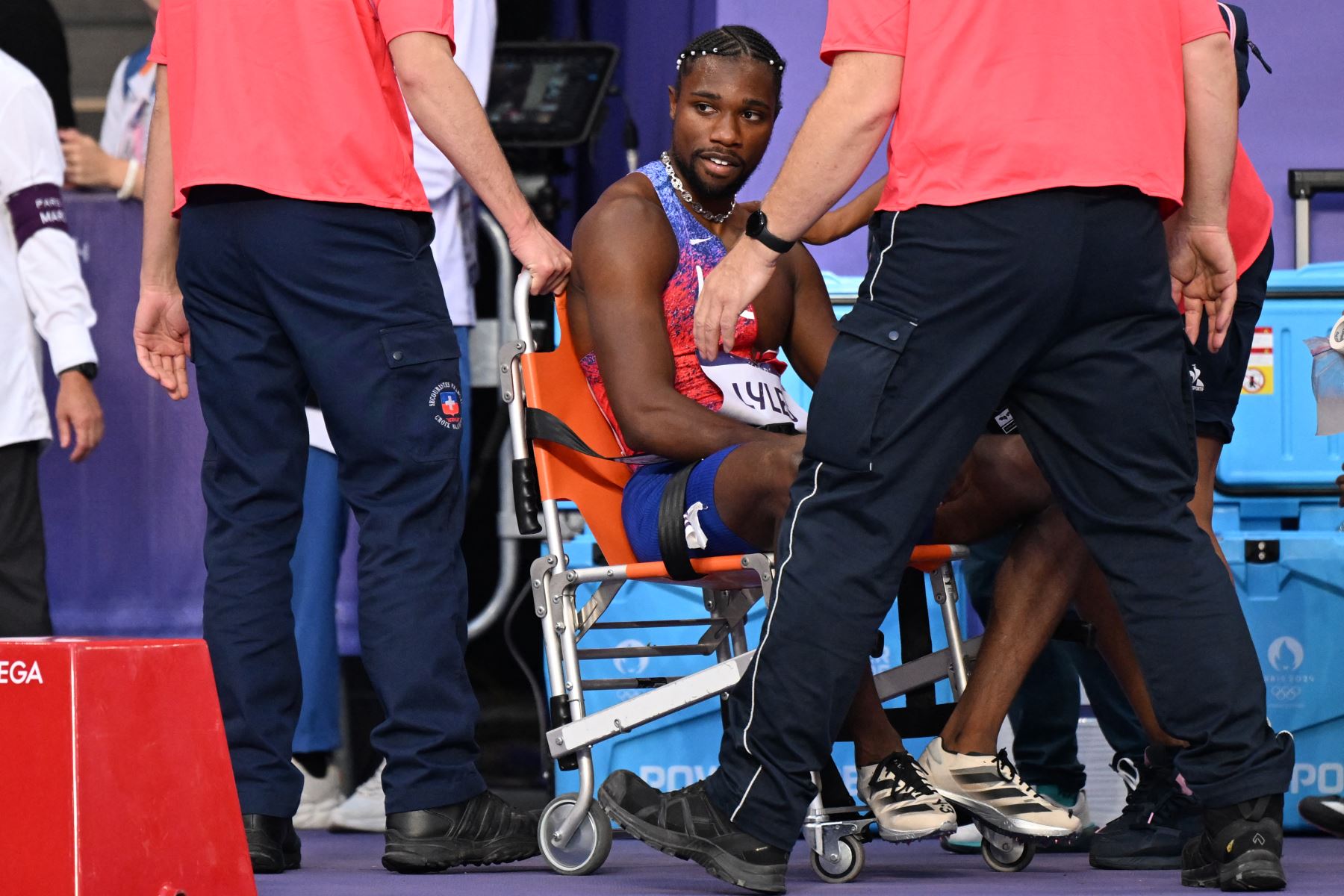 El medallista de bronce estadounidense Noah Lyles  recibe atención médica después de competir  con diagnostico de covid, en la final masculina de 200 metros de la prueba de atletismo de los Juegos Olímpicos de París 2024. AFP