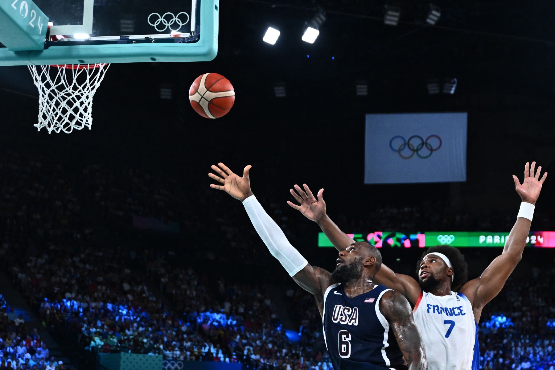 LeBron James  de EE. UU., lanza una pelota frente  a Guerschon Yabusele de Francia en el partido de baloncesto masculino por la medalla de oro entre Francia y EE. UU. durante los Juegos Olímpicos de París 2024.
Foto: AFP